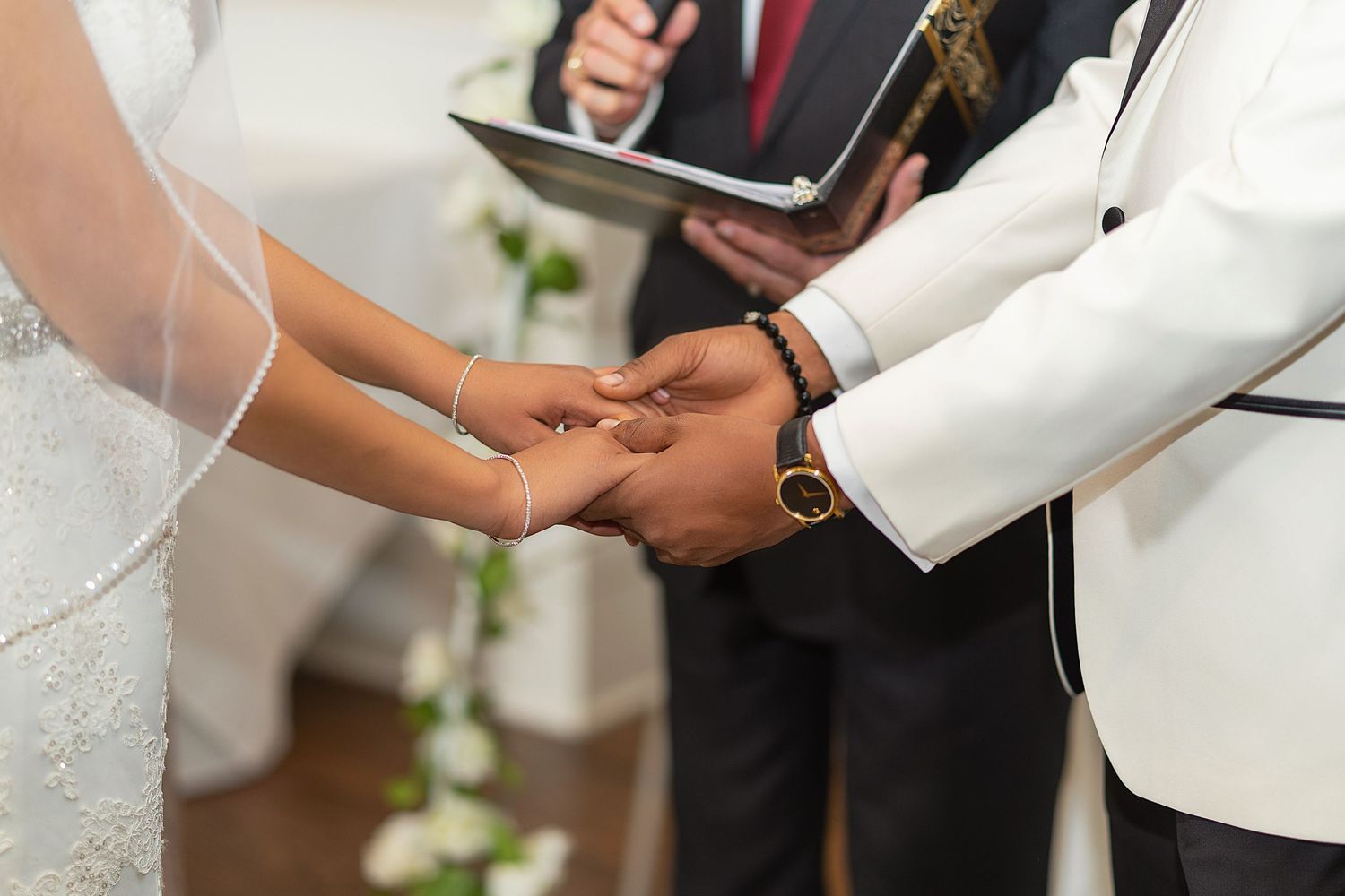 Hands of a bride and groom exchanging wedding rings during an intimate ceremony.