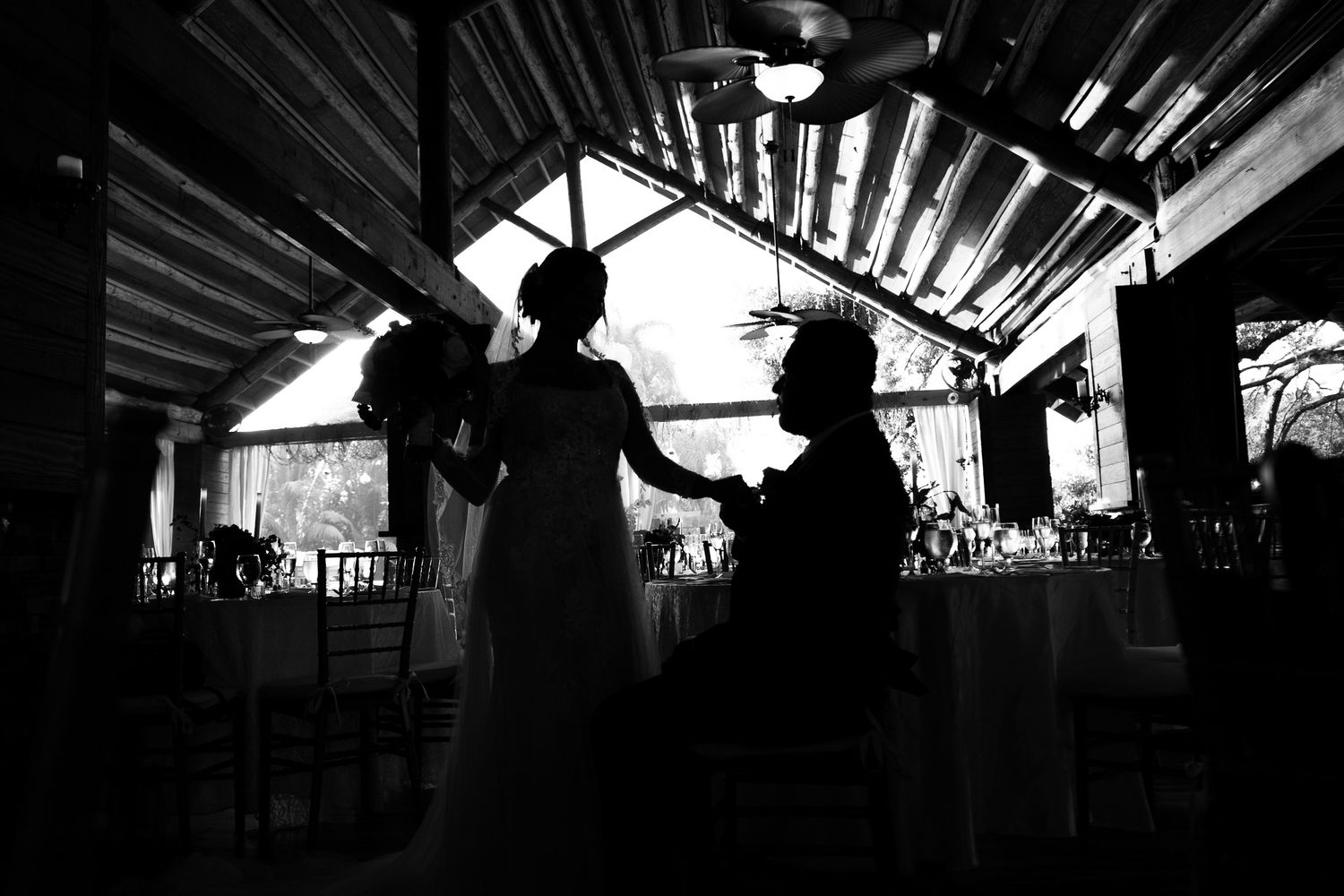 A silhouetted figure stands in a darkened architectural space with dramatic diagonal lines and beams overhead.