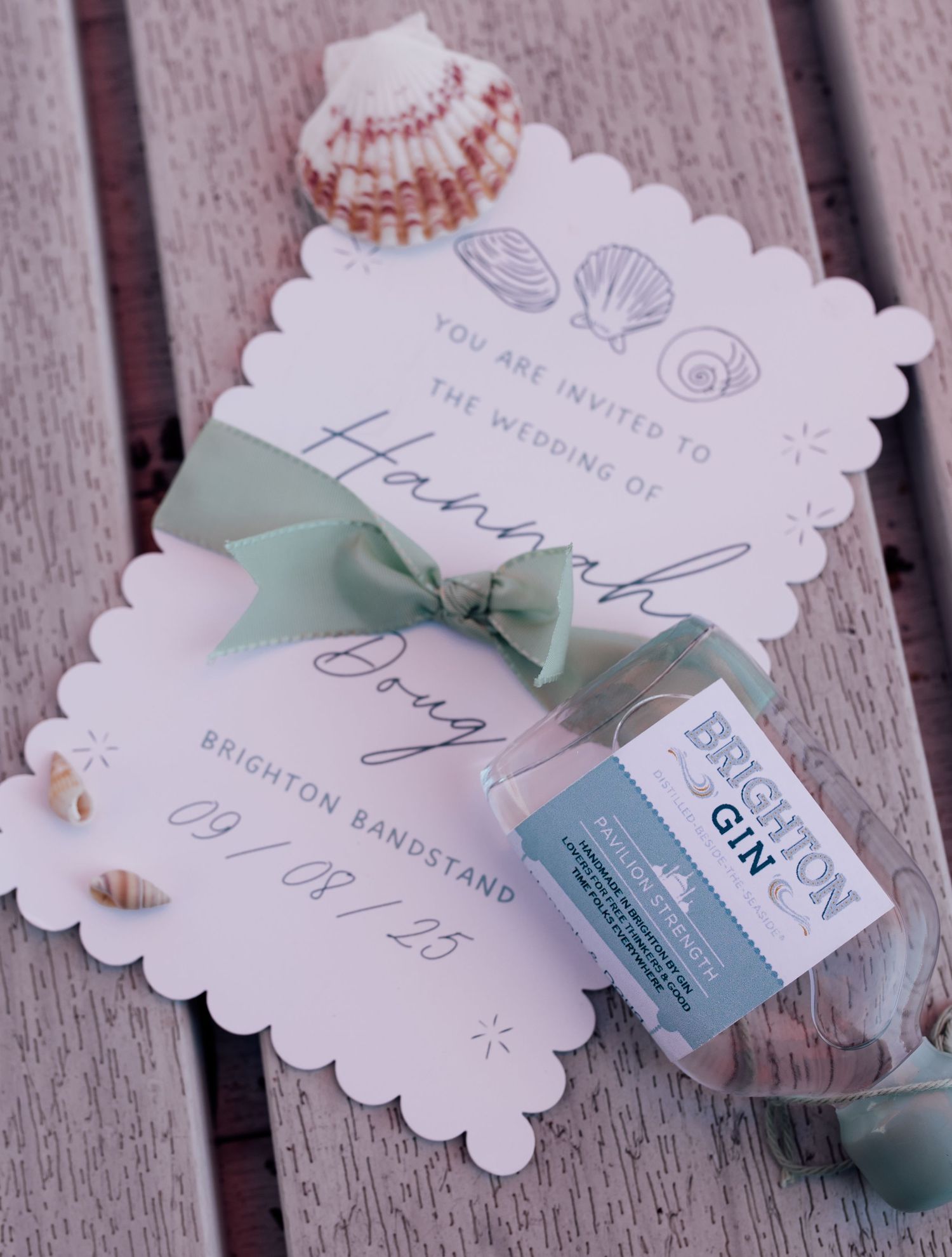 Wedding favor tags with scalloped edges and mint green ribbons display elegant text and seashell designs.