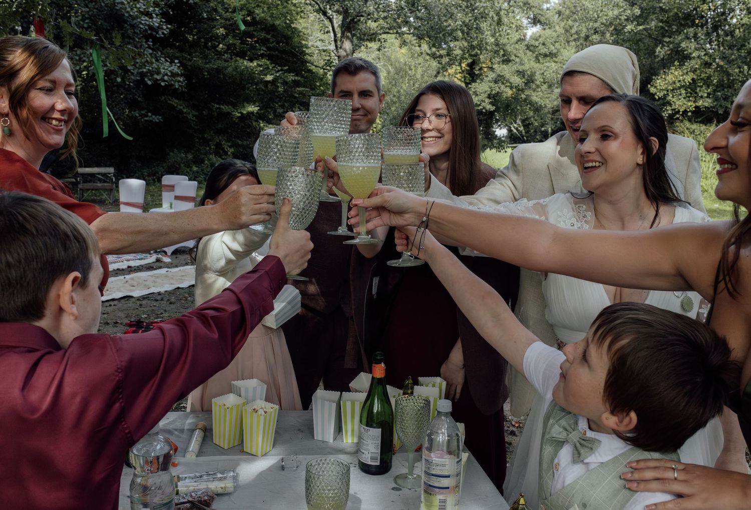 A group of people toasting and clinking glasses together in celebration at a gathering.