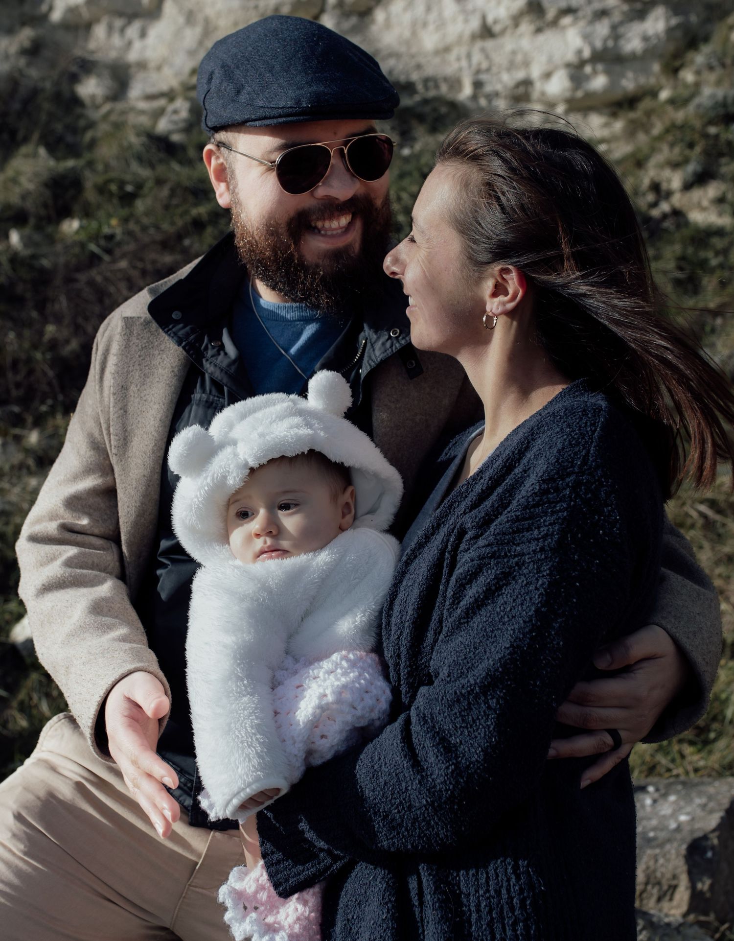 A series of intimate outdoor family photos showing tender moments between parents and their baby in winter attire.