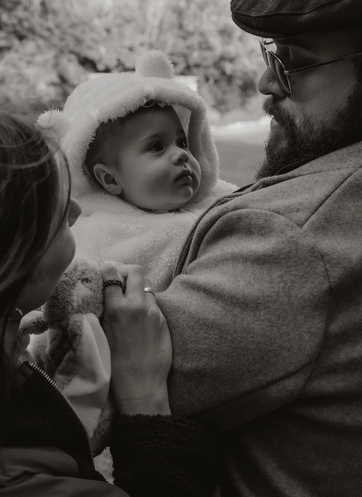 A tender black and white photo series showing intimate moments between a parent and baby in close-up shots.