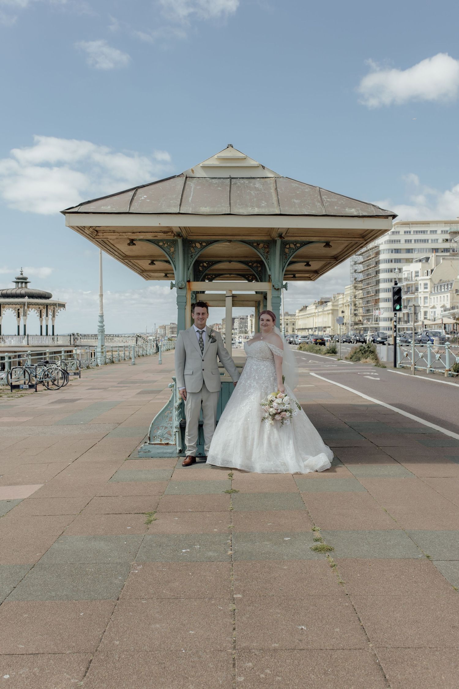 A series of five connected photos showing a seaside promenade with Victorian-style covered shelters along Brighton beach.