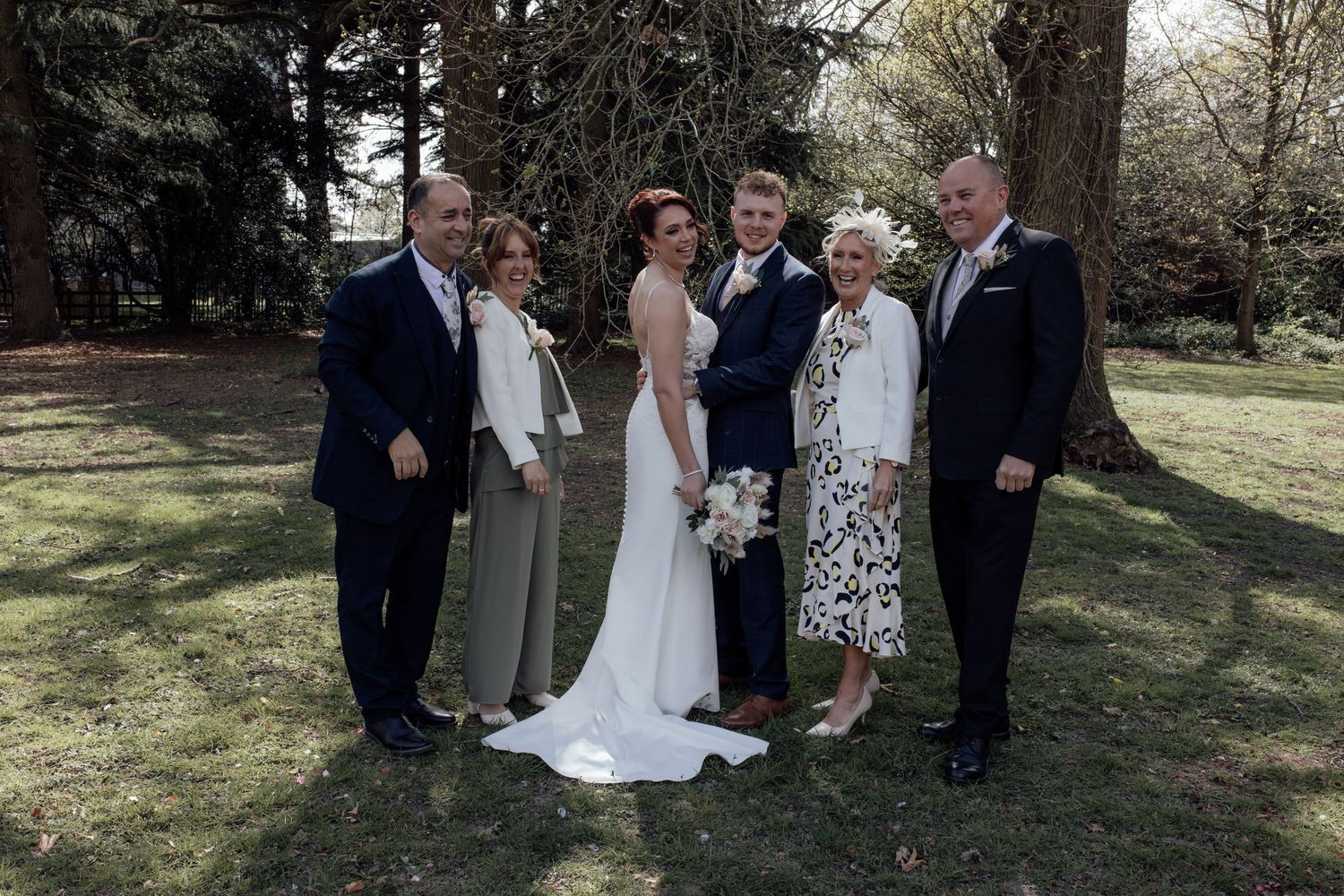 Bride and groom stand with family for a family group photo
