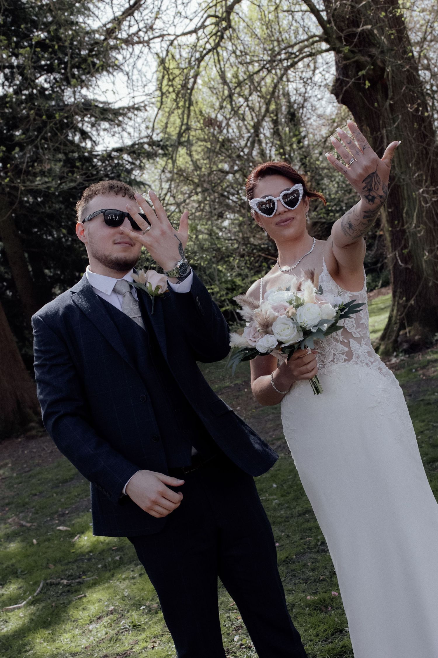 Bride and Groom hold up hands with their wedding rings showing.