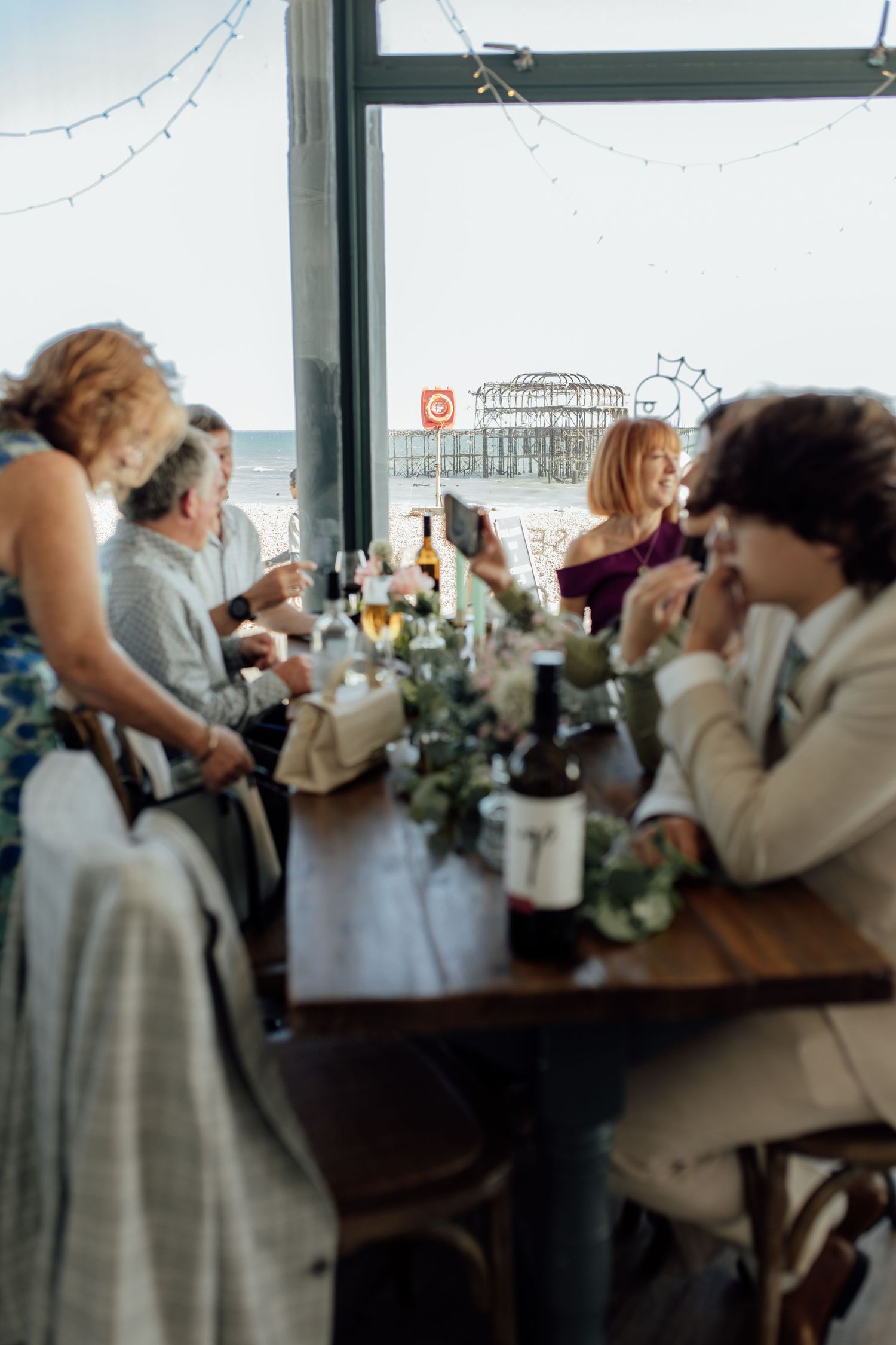 A sequence of candid moments from a wedding reception showing guests mingling and celebrating in an indoor venue.