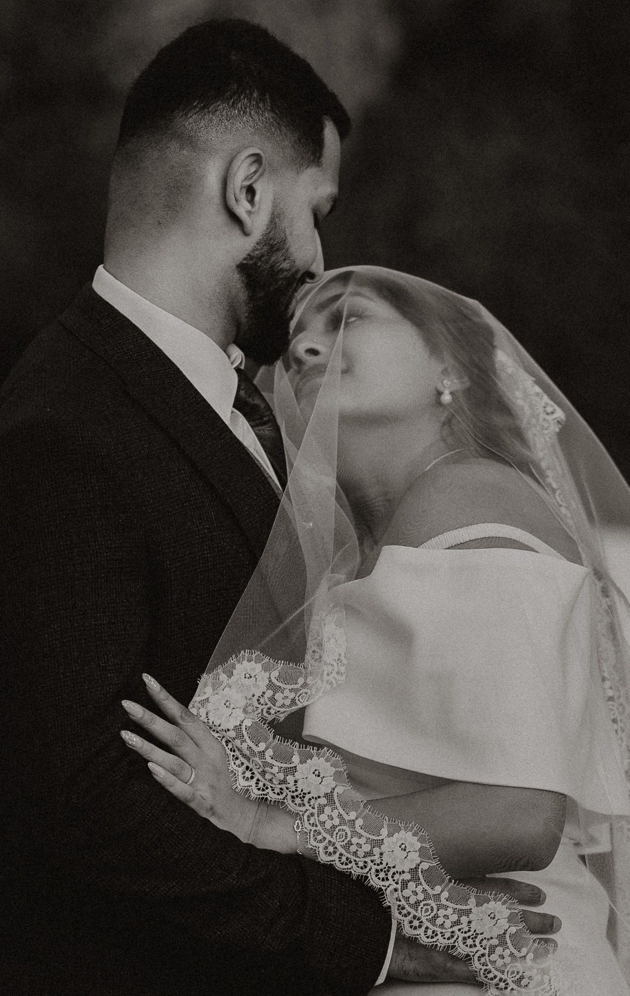 Intimate black and white wedding portraits capturing tender moments between newlyweds.