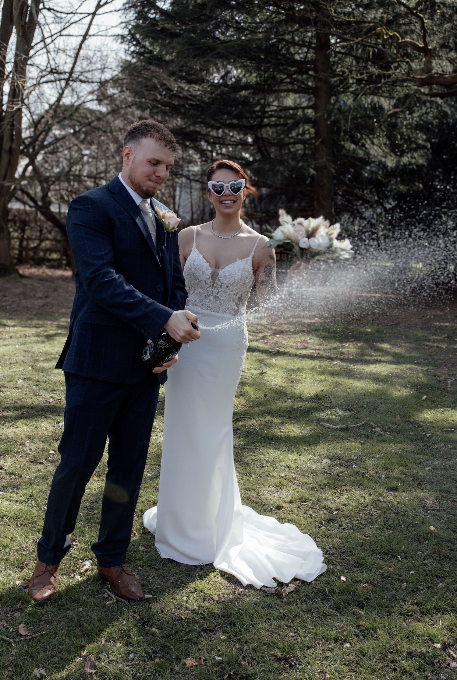 Bride and groom having a champagne spray to celebrate their marriage.