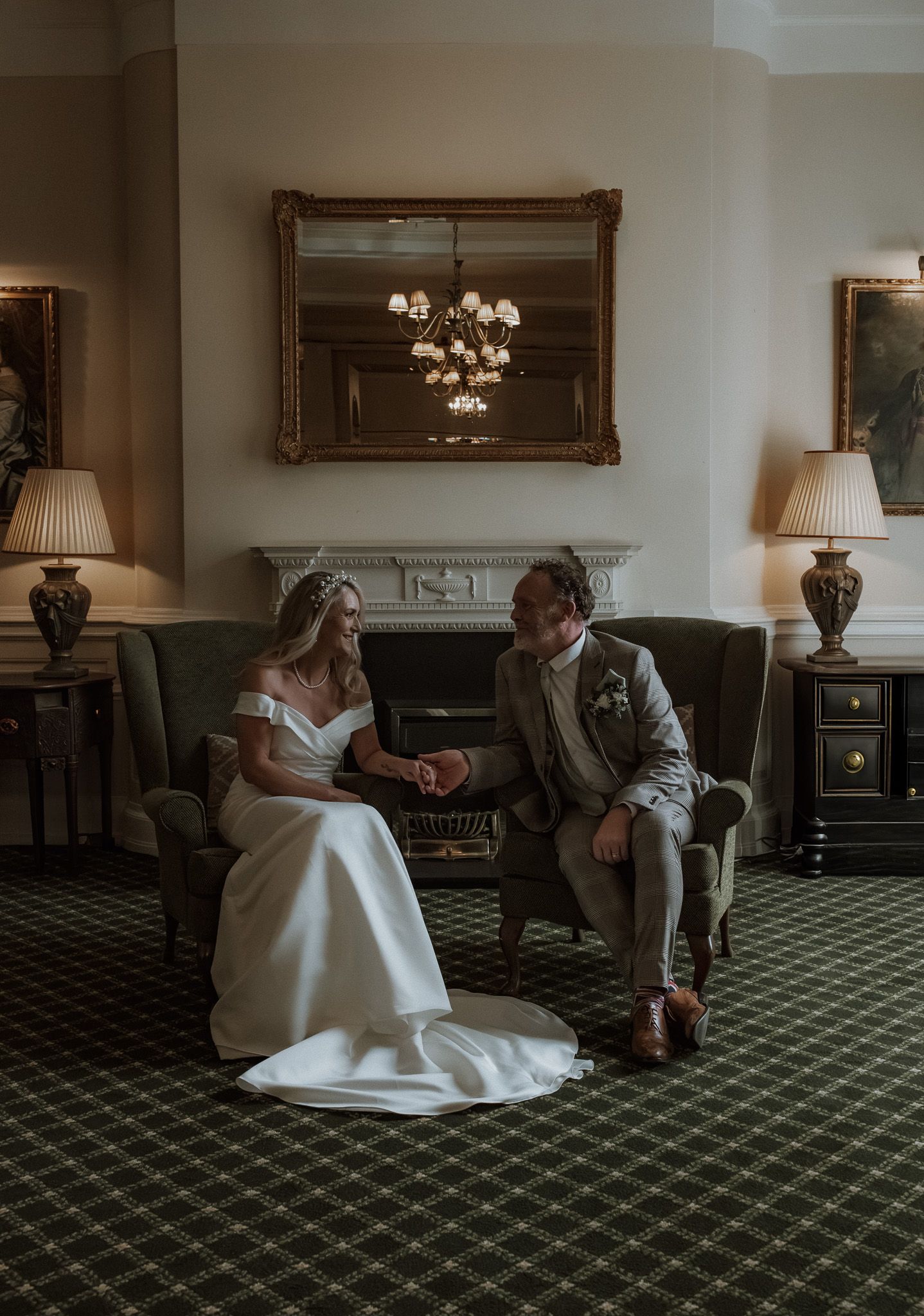 Elegant hotel lounge with green carpet and vintage furniture where wedding moments are captured.