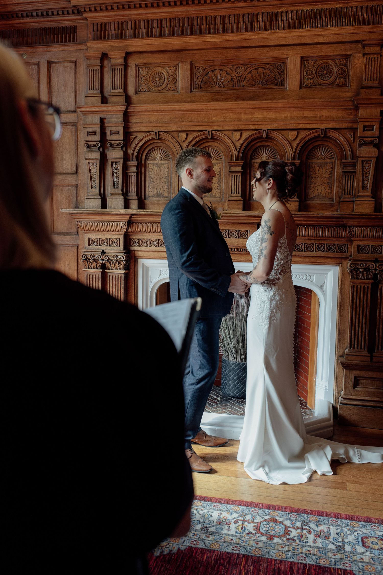Bride and groom stand before a register saying their wedding vows
