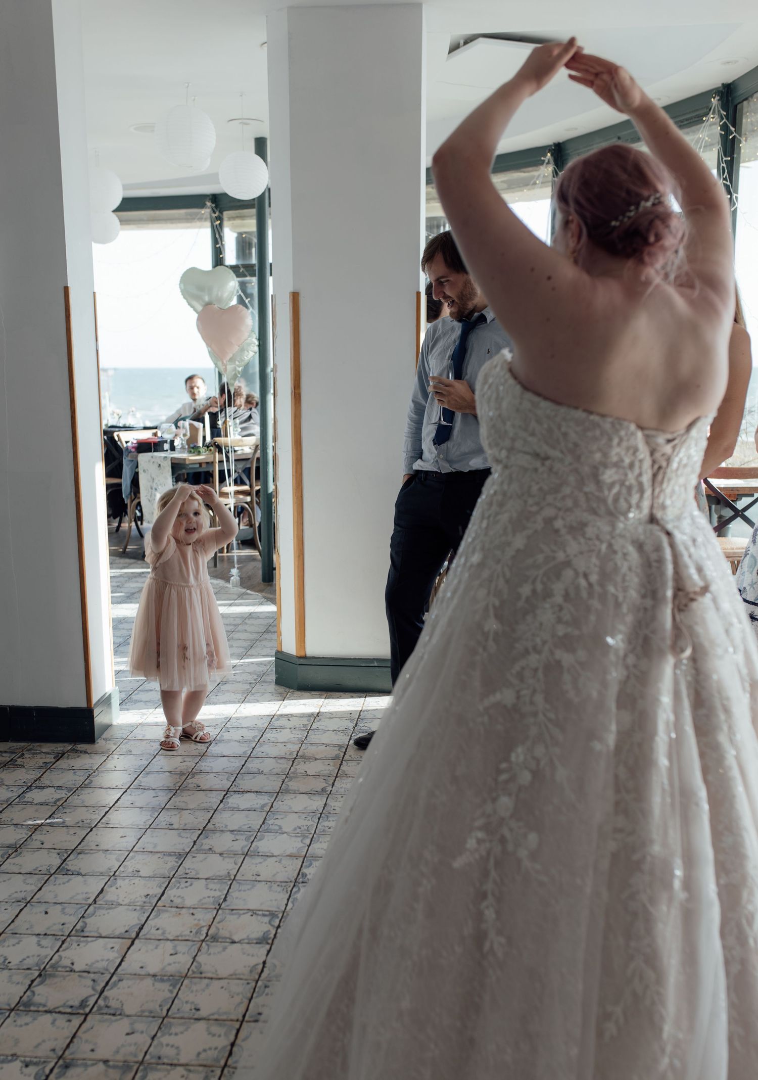 A person in a white lace wedding dress twirls and dances in a series of connected photos showing fluid movement.