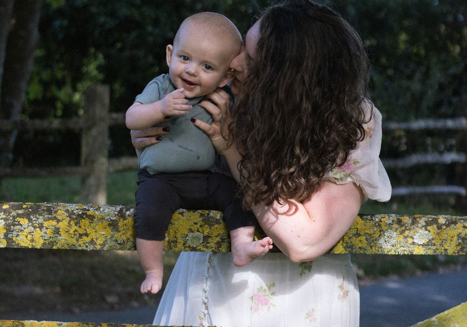 A series of photos showing a parent holding and embracing a baby in an outdoor setting with yellow flowers.