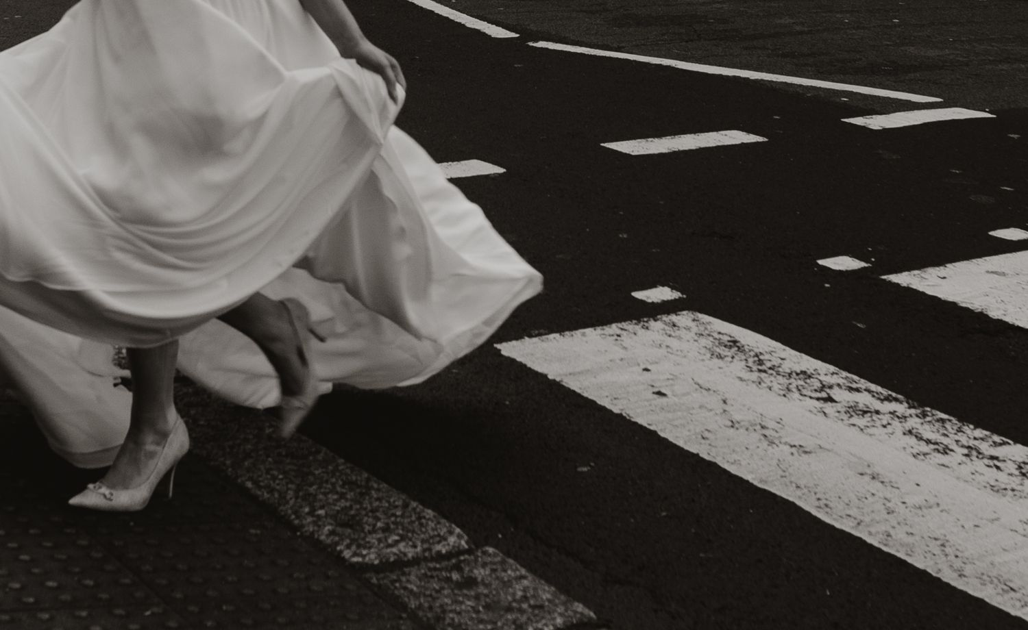 Dramatic black and white photos of wedding dress details trailing across floor.