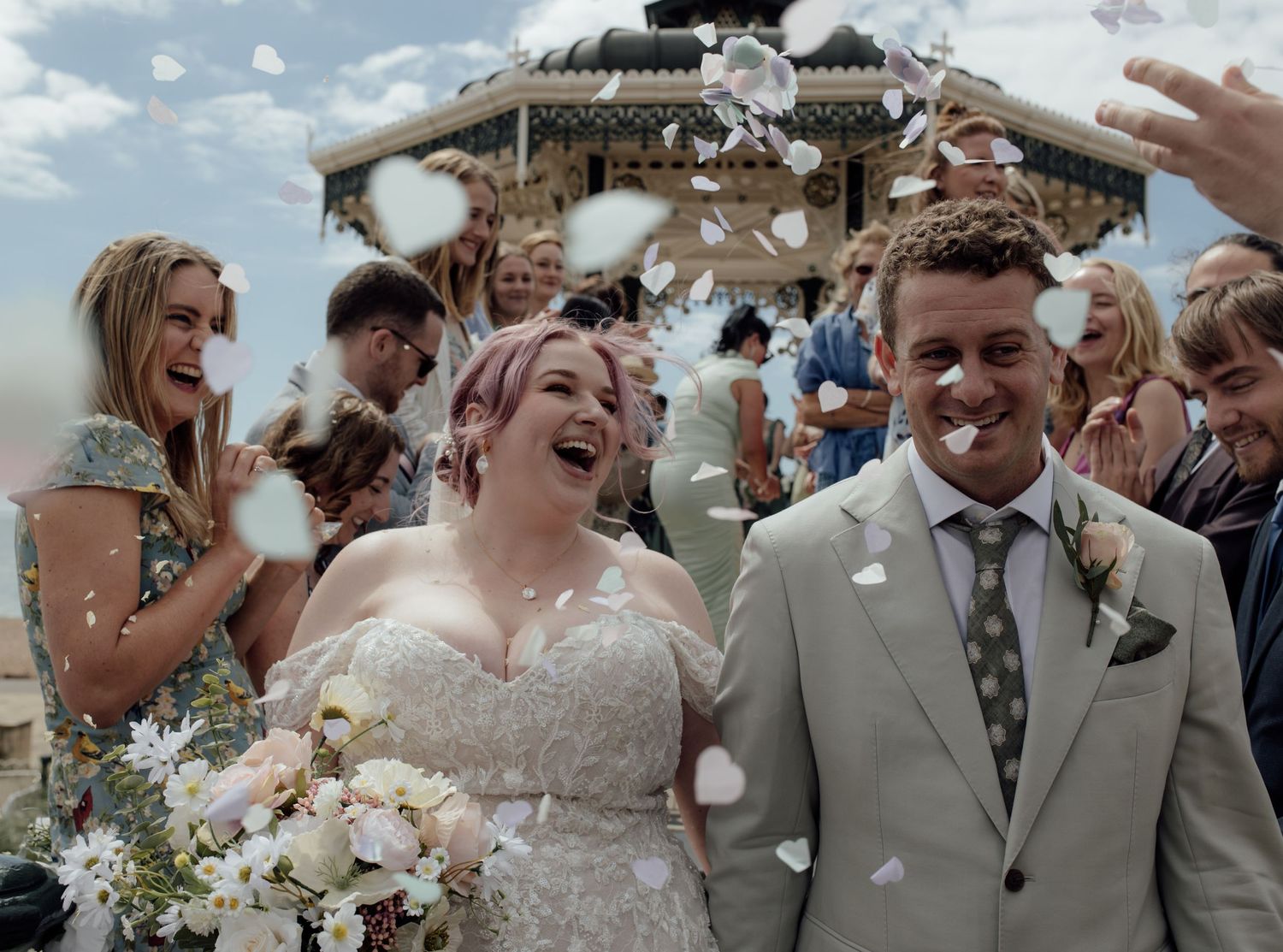 A joyful wedding celebration sequence showing the happy couple and guests during an outdoor ceremony.