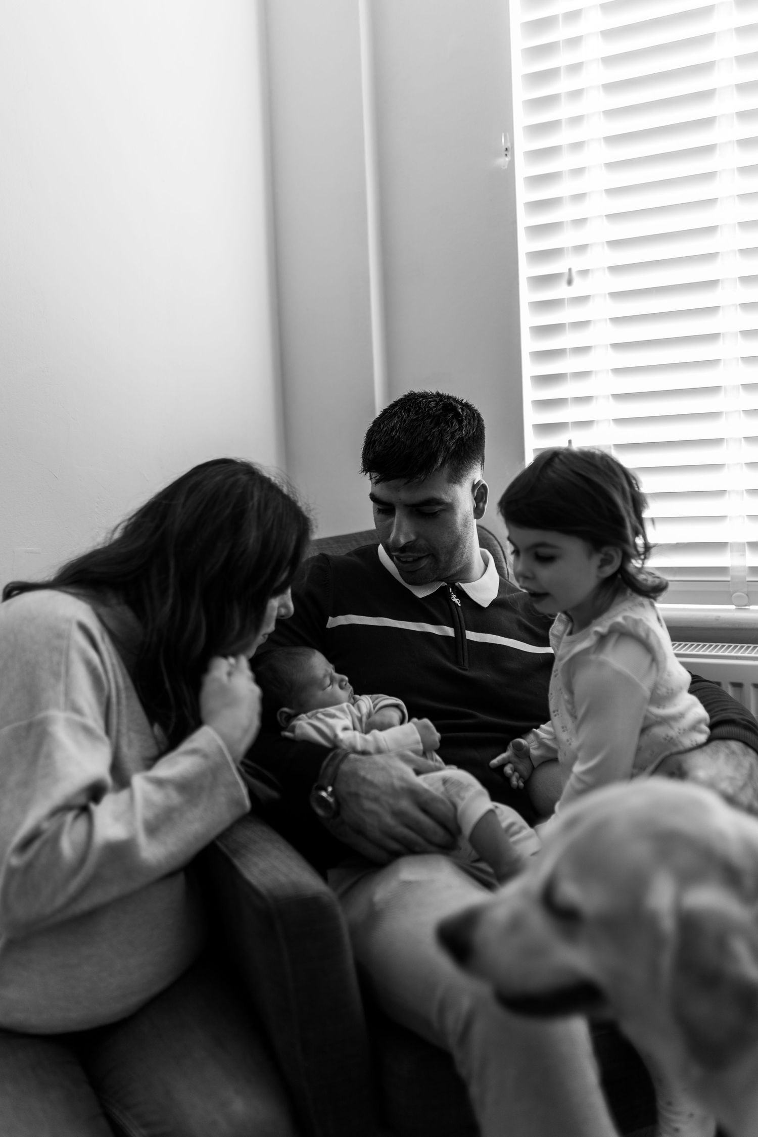 Black and white sequence showing people leaning in closer together in a group huddle formation near a window.