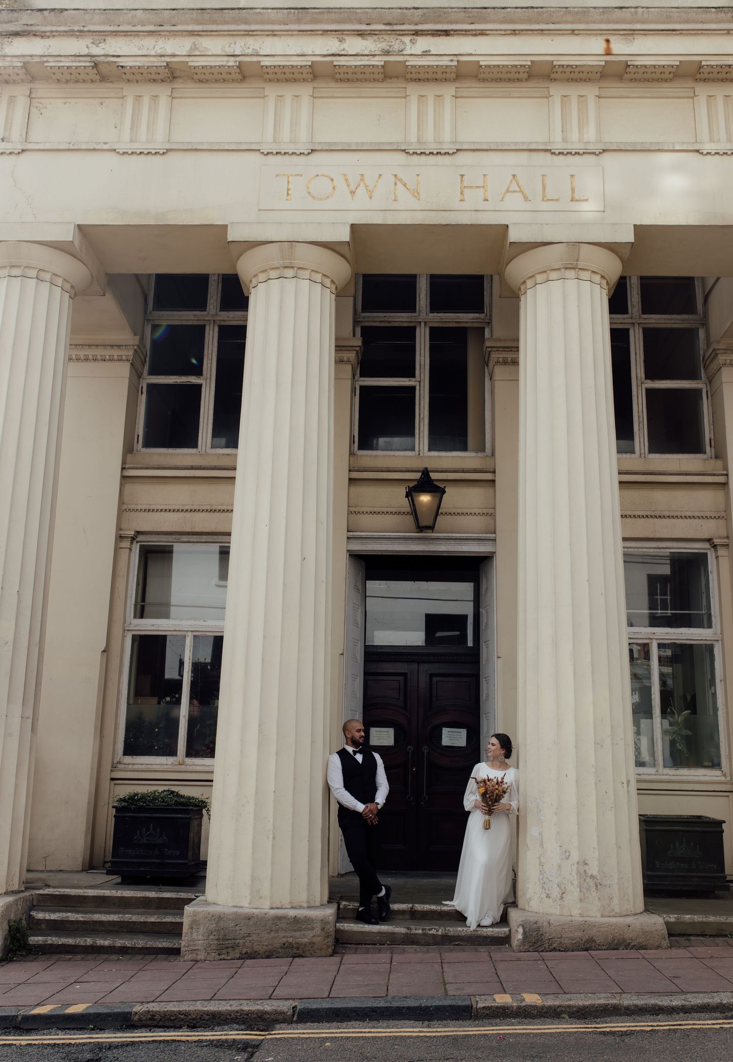 White columns line the entrance of a historic town hall building with classic architectural details.