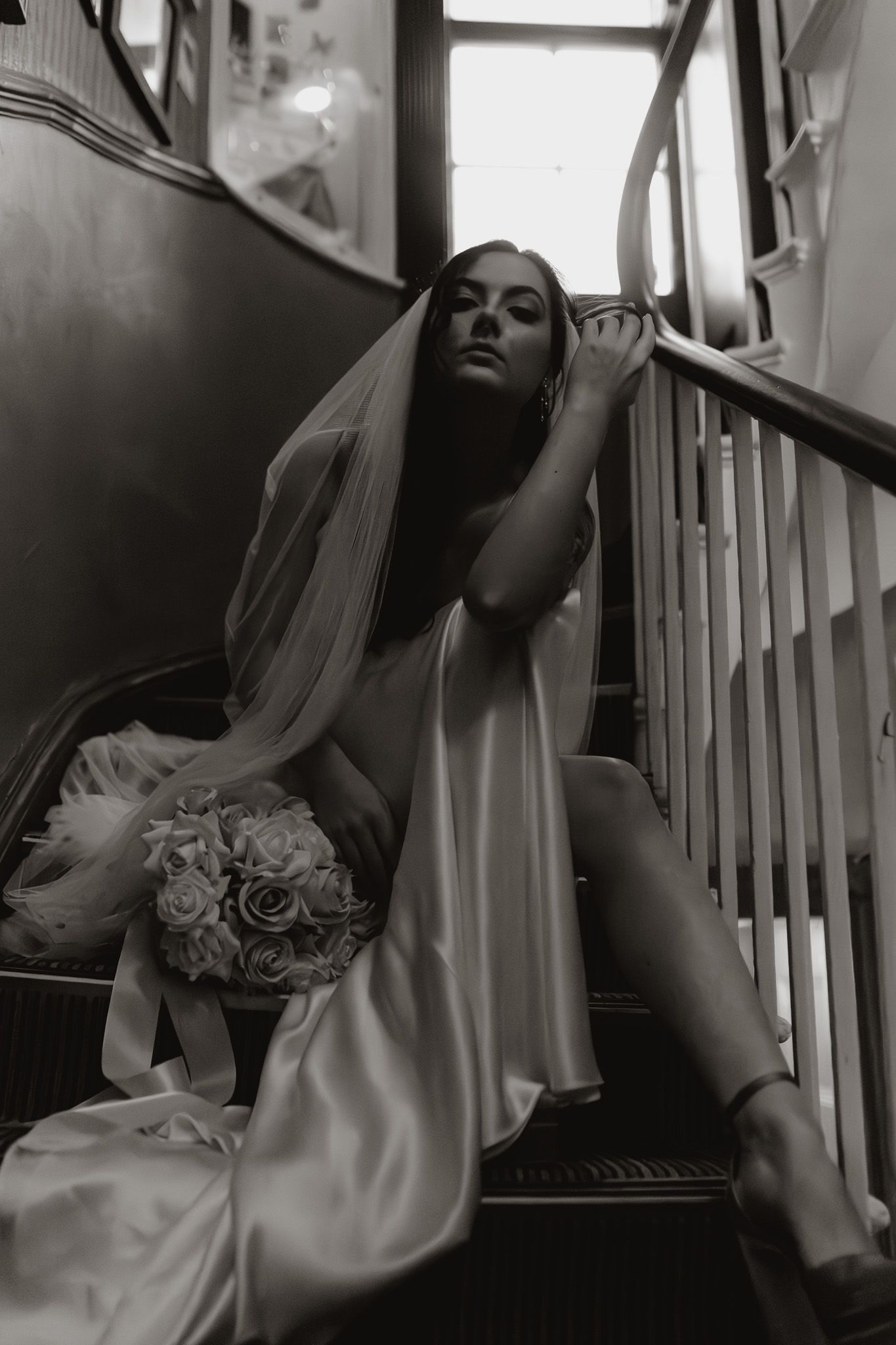 Dramatic black and white bridal portraits on a wooden staircase.