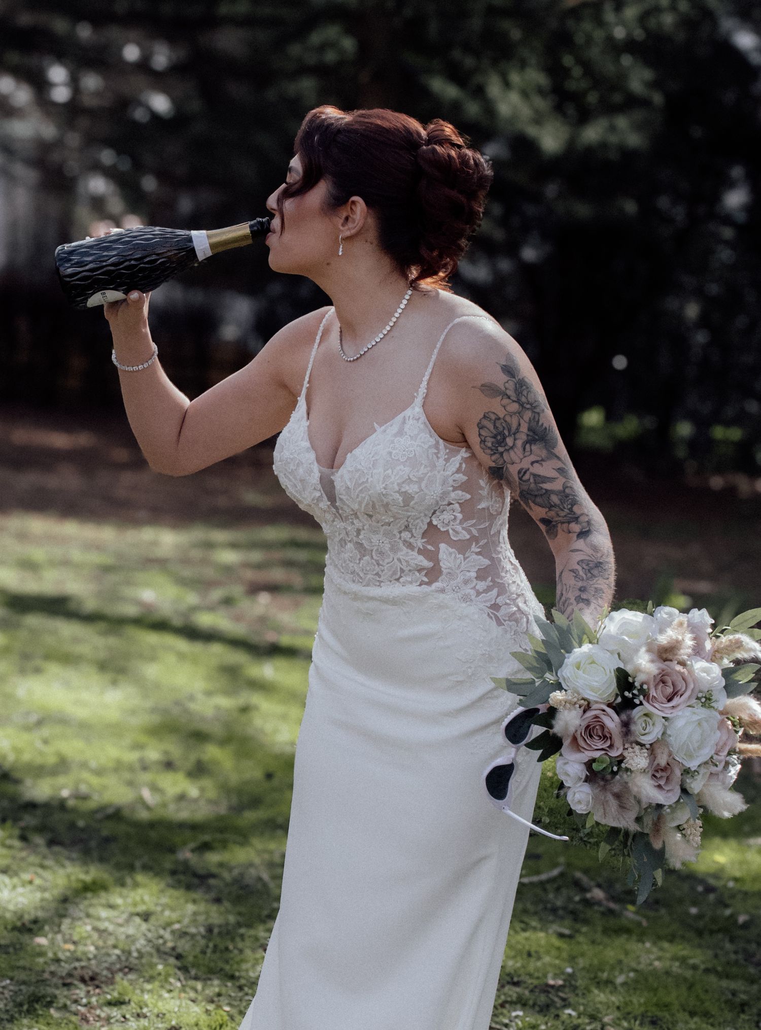 Bride drinking from a champagne bottle.