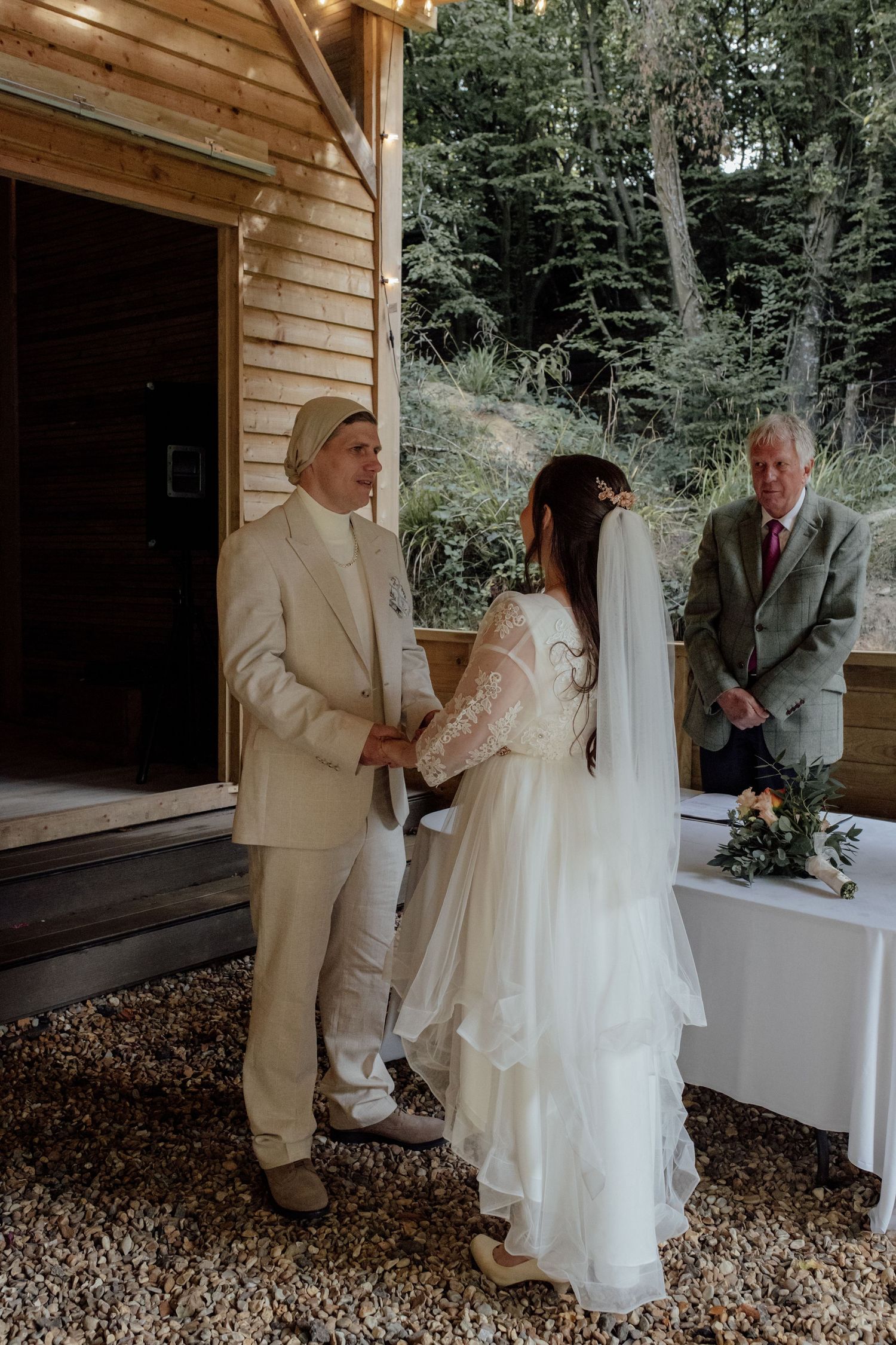 A wedding ceremony sequence shows a couple exchanging vows in a rustic wooden pavilion setting.