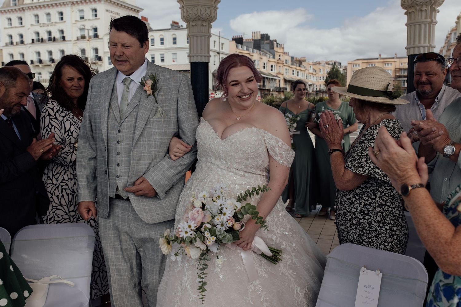 Wedding party celebrates with joyful expressions during outdoor reception in urban setting.