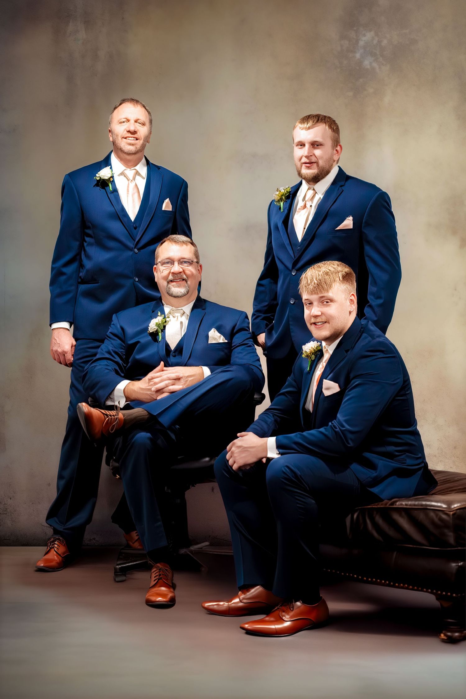 “Groom and groomsmen posing with two seated in front and two standing behind them.”