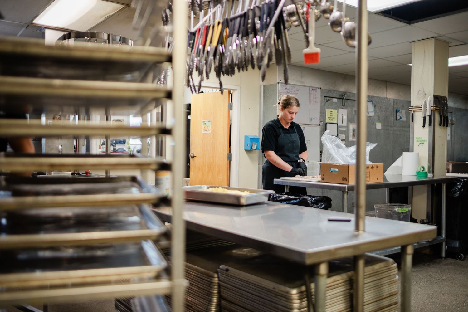 Laboratory workspace showing various scientific equipment and storage areas with metal tables and shelving units.