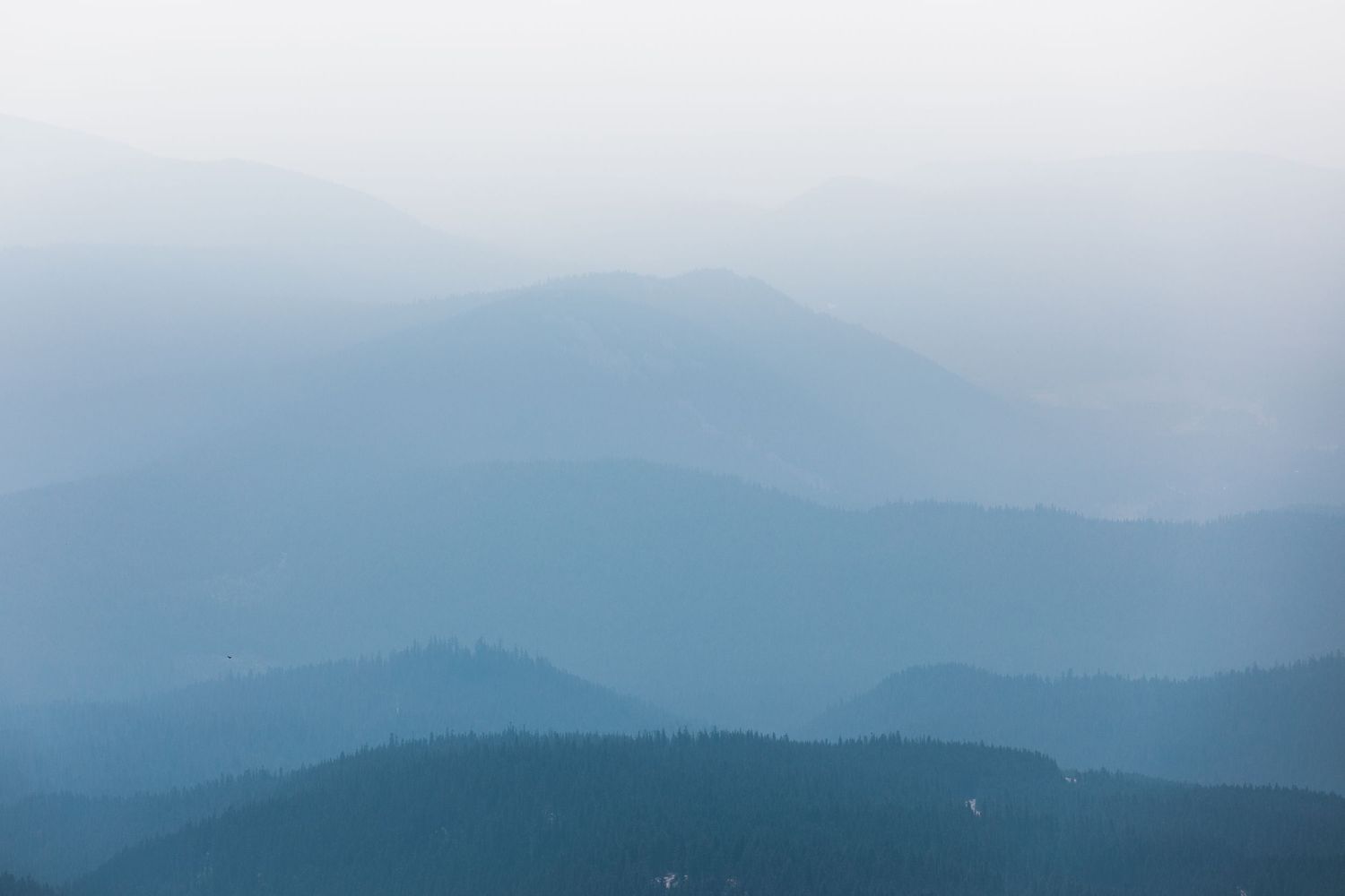 Misty blue mountain ranges create layers of silhouettes fading into the distance.