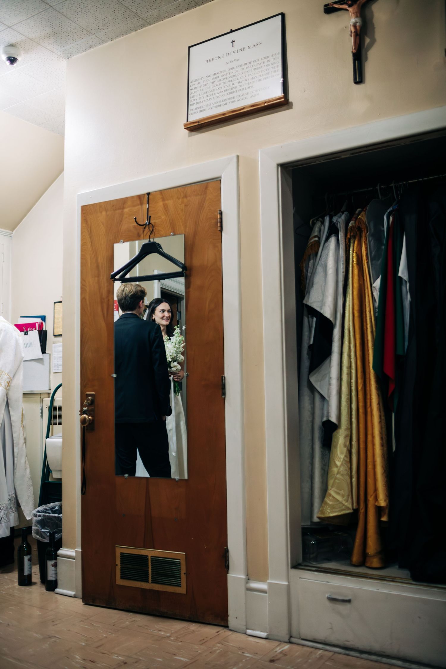 A wedding day reflection in a mirror showing a couple sharing a moment in a dressing room.