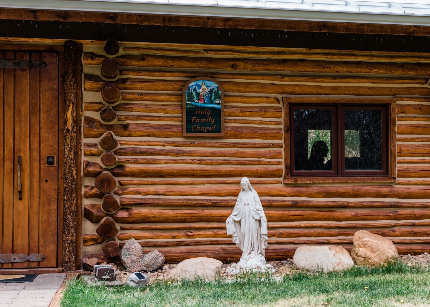 Rustic log cabin exterior with wooden siding and decorative elements visible in bright daylight.