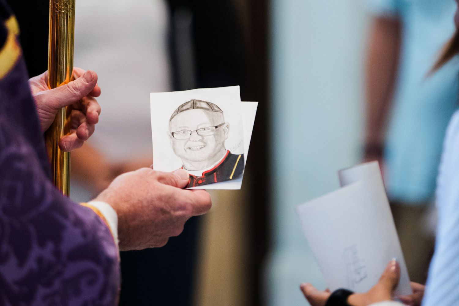 A close-up view of hands holding small business cards or photographs during a networking event.