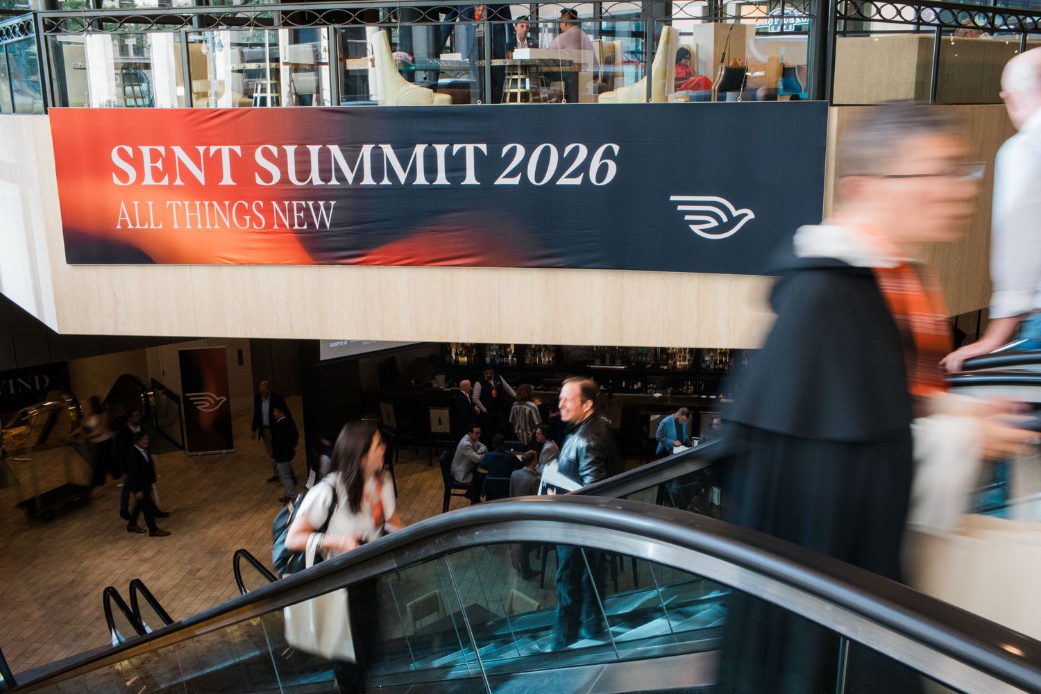 Escalators and attendees at Sent Summit 2026 All Things New conference inside a modern convention center.
