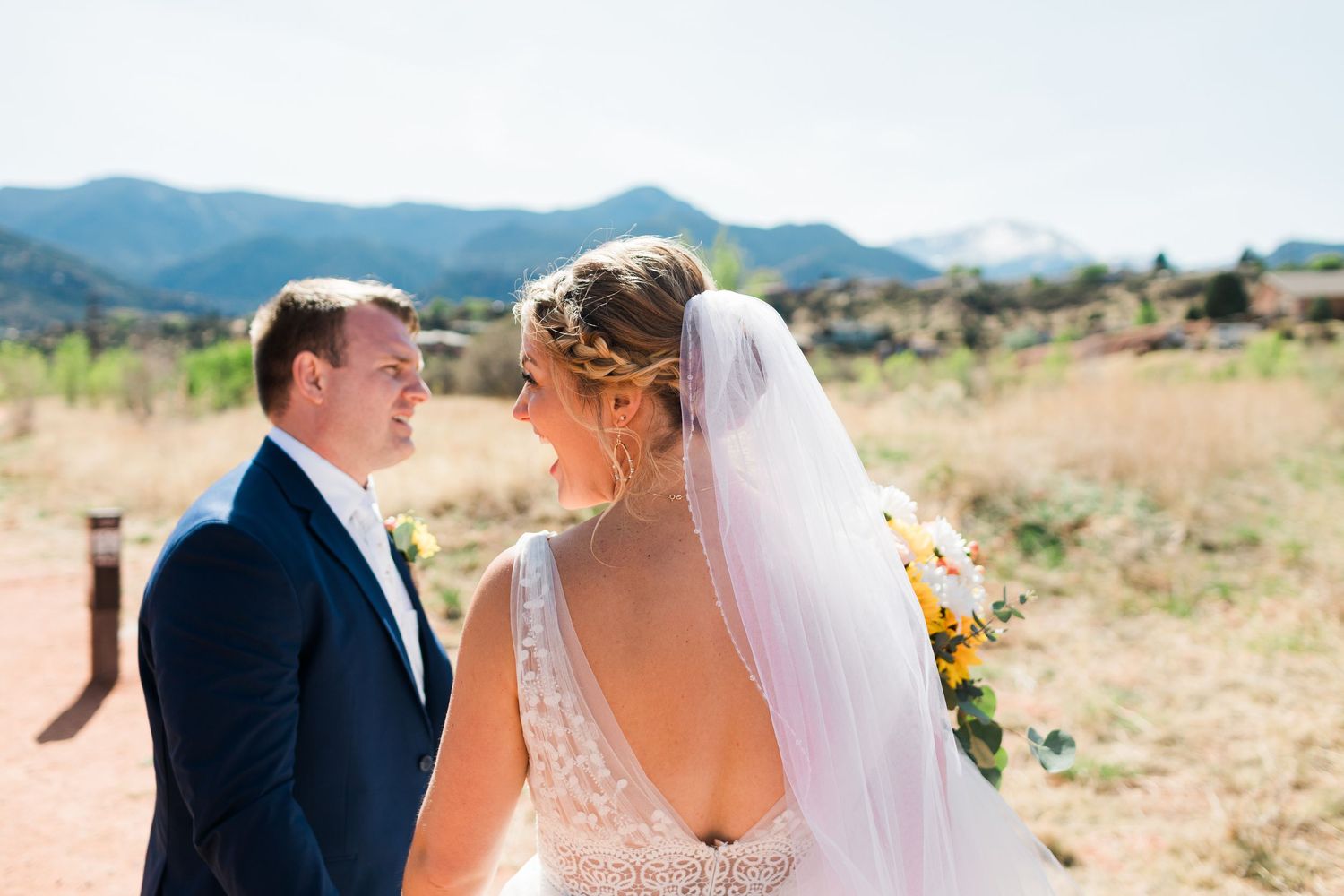 Bride and groom share a romantic moment with scenic Colorado mountains in the background on their wedding day.