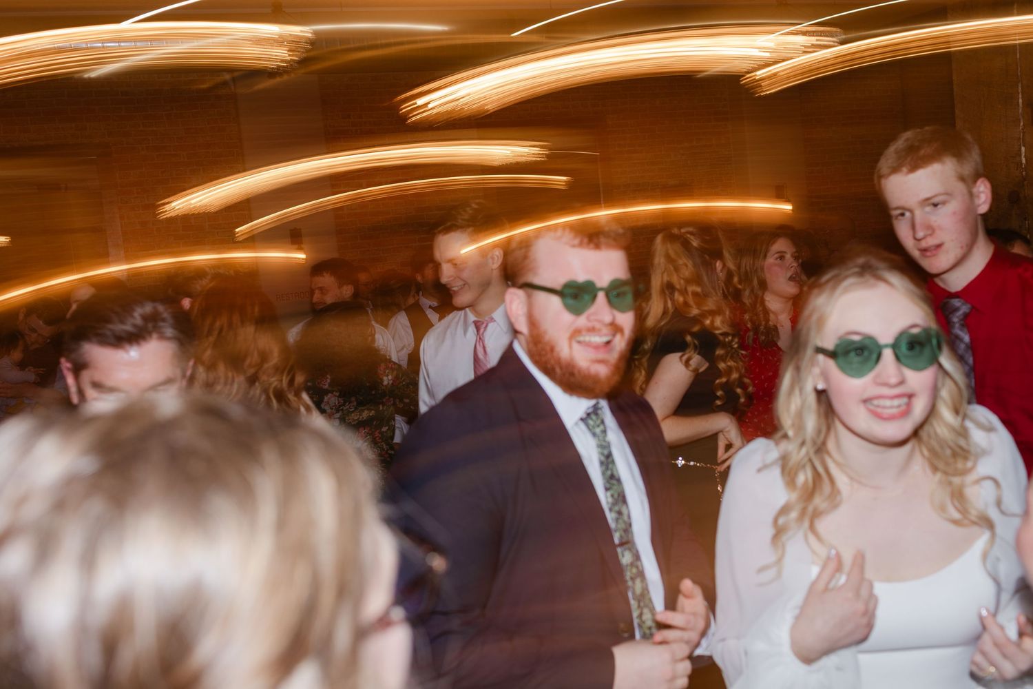 Motion-blurred dance floor photos show people celebrating at a formal event with warm lighting and elegant decor.