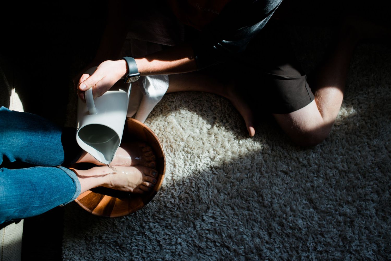 Hands pour water into a vessel during a religious ceremony.