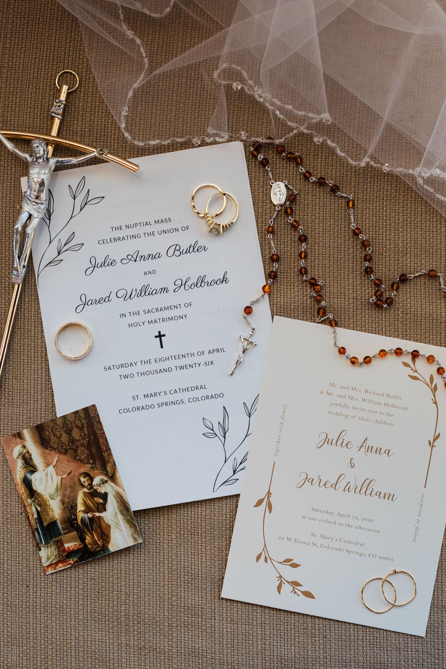 Catholic wedding invitation suite with rings, rosary beads, and crucifix for Julie Anna Butler and Jared William Holbrook.