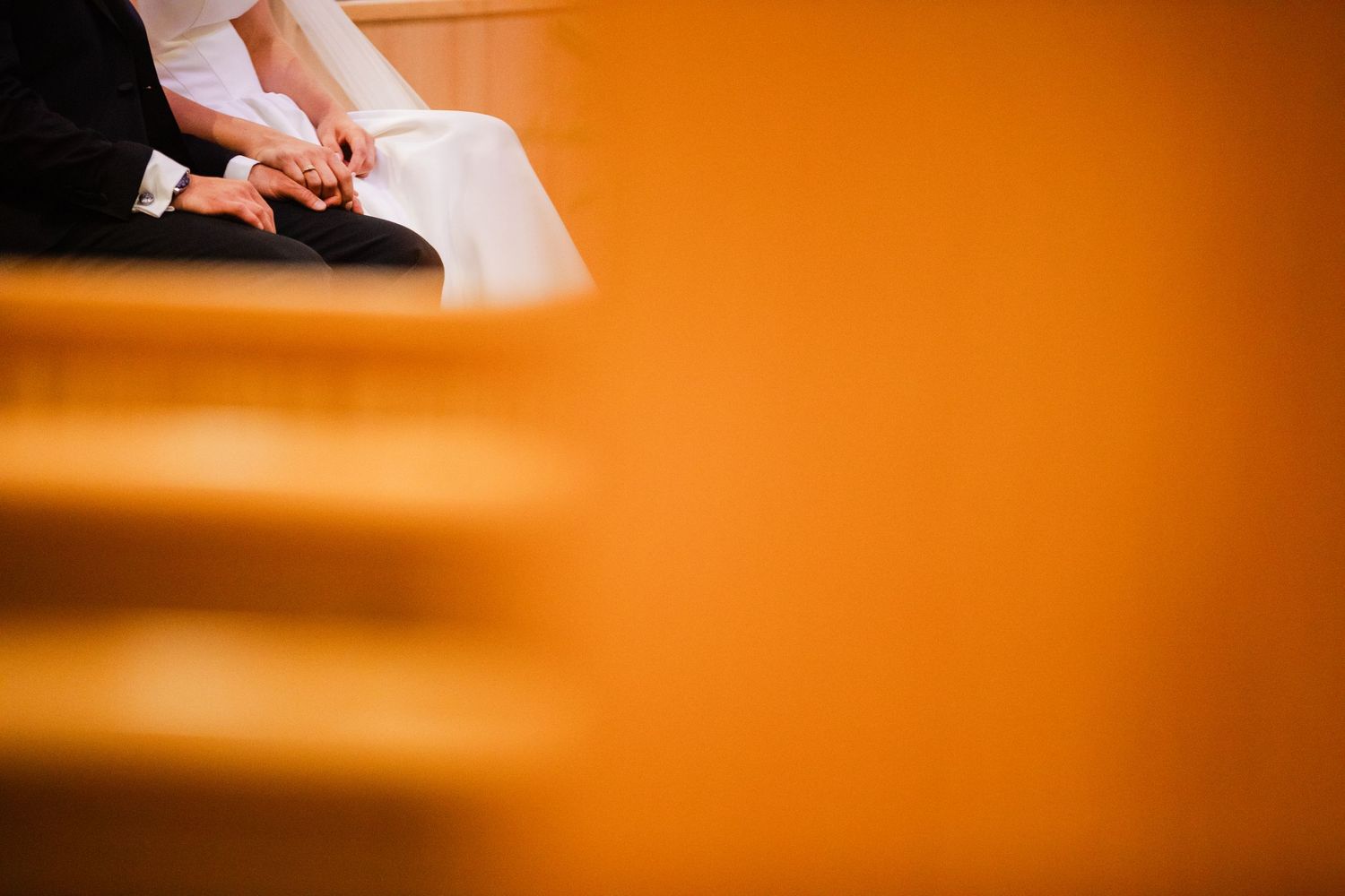 Hands holding papers against an orange background in dramatic lighting.