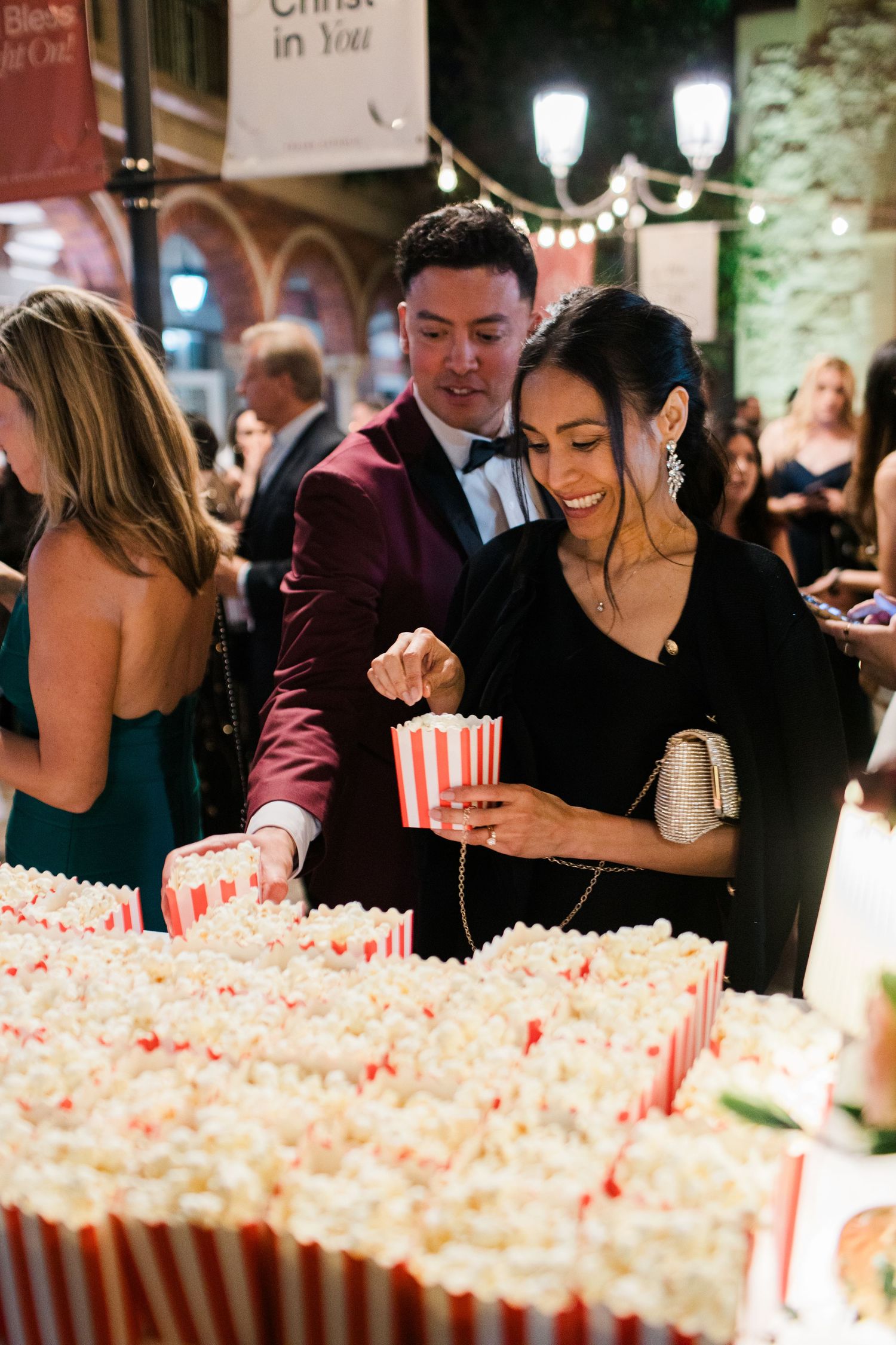 Rows of popcorn boxes lined up at an event with people serving and gathering around them.