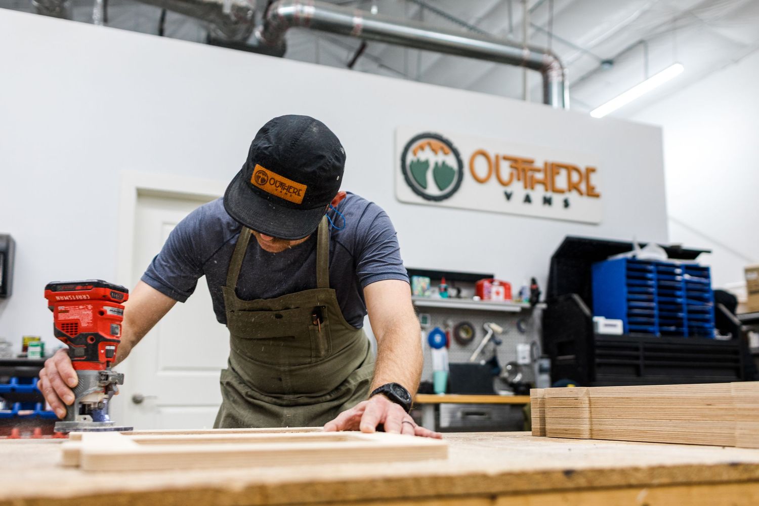 Craftsmen working on wooden furniture pieces in a professional workshop with tools and equipment.
