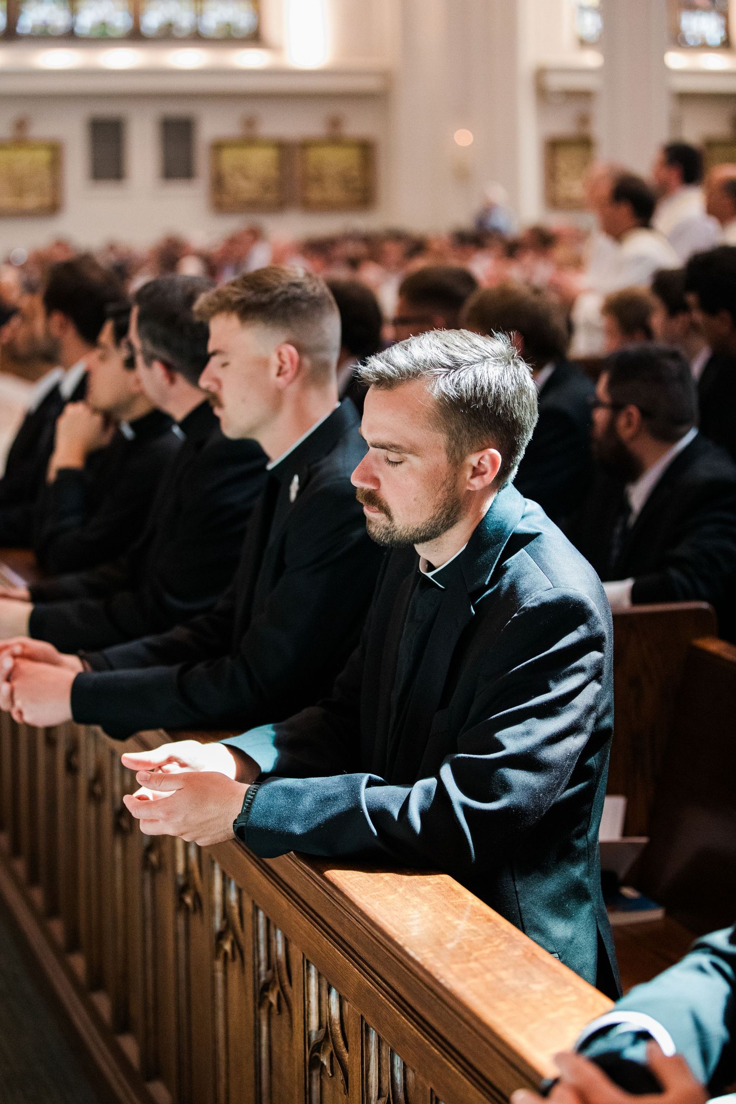 Congregation members sit in wooden pews during a church service.