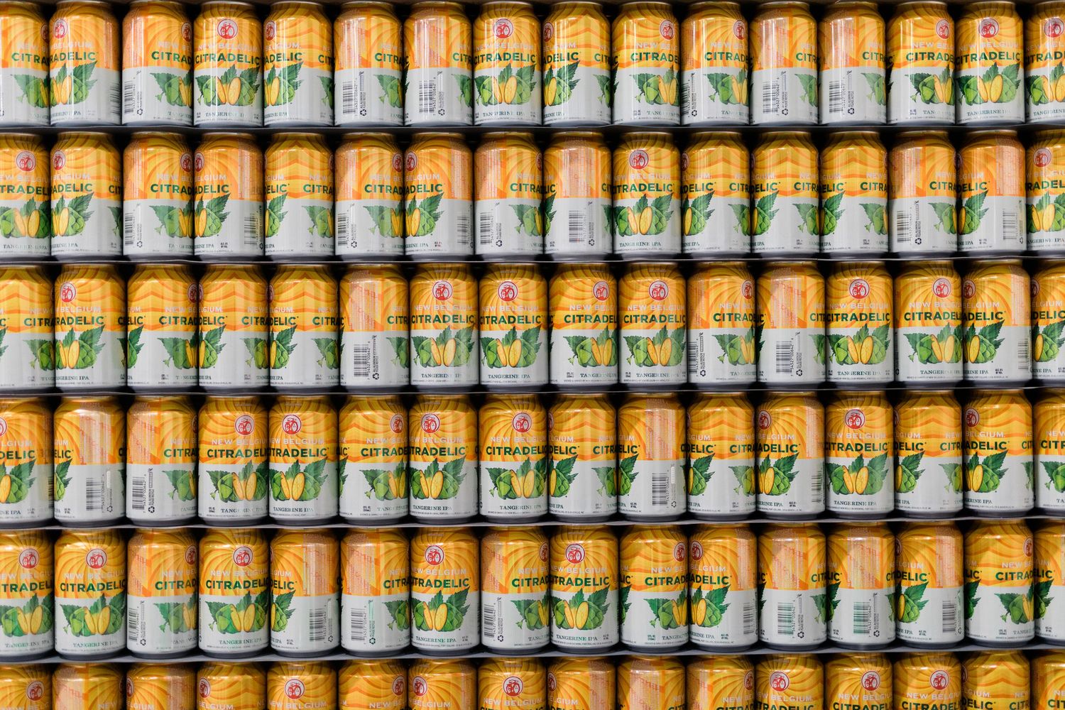 Rows of orange and white beer cans stacked neatly on retail shelves displaying consistent brewery branding.