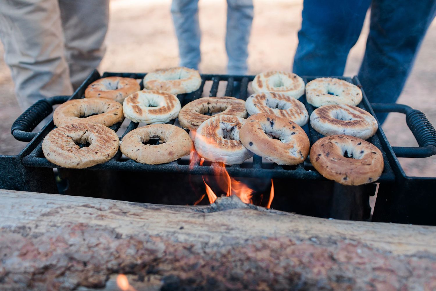 Bagels cooking on an outdoor grill during a camping trip.