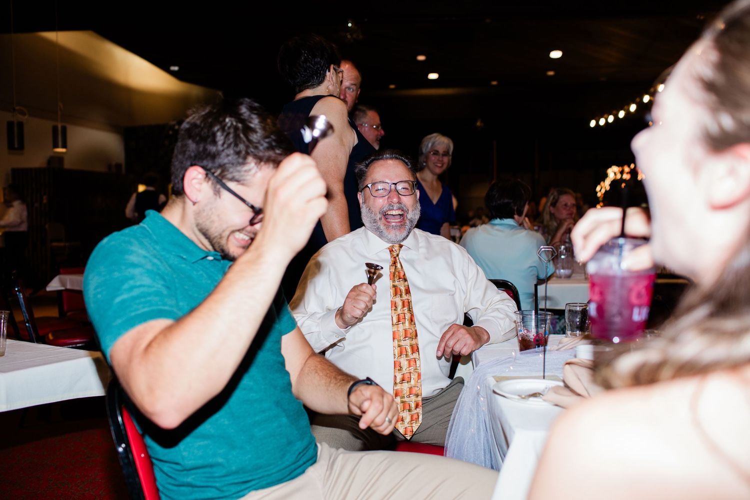 A series of candid reception photos showing guests dancing and celebrating at a dimly lit wedding venue.