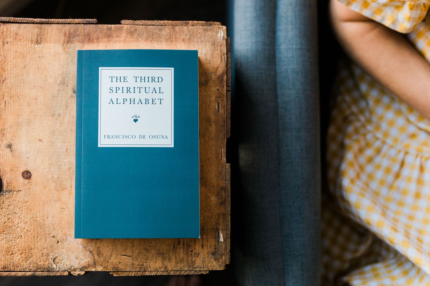 A collection of vintage books and notebooks with worn covers arranged on a blue textured background.
