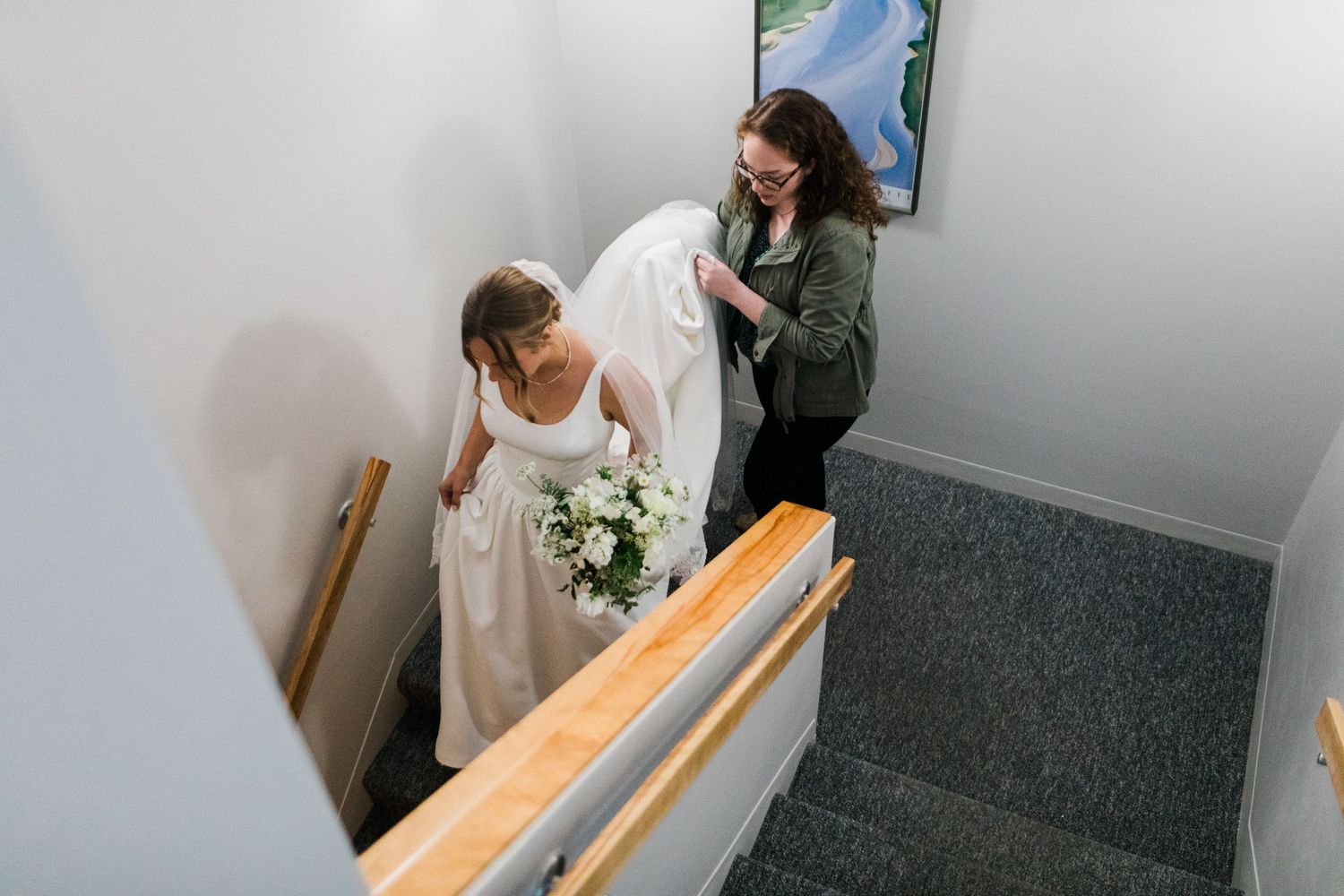 A group carries a casket down a narrow staircase during a solemn funeral service.