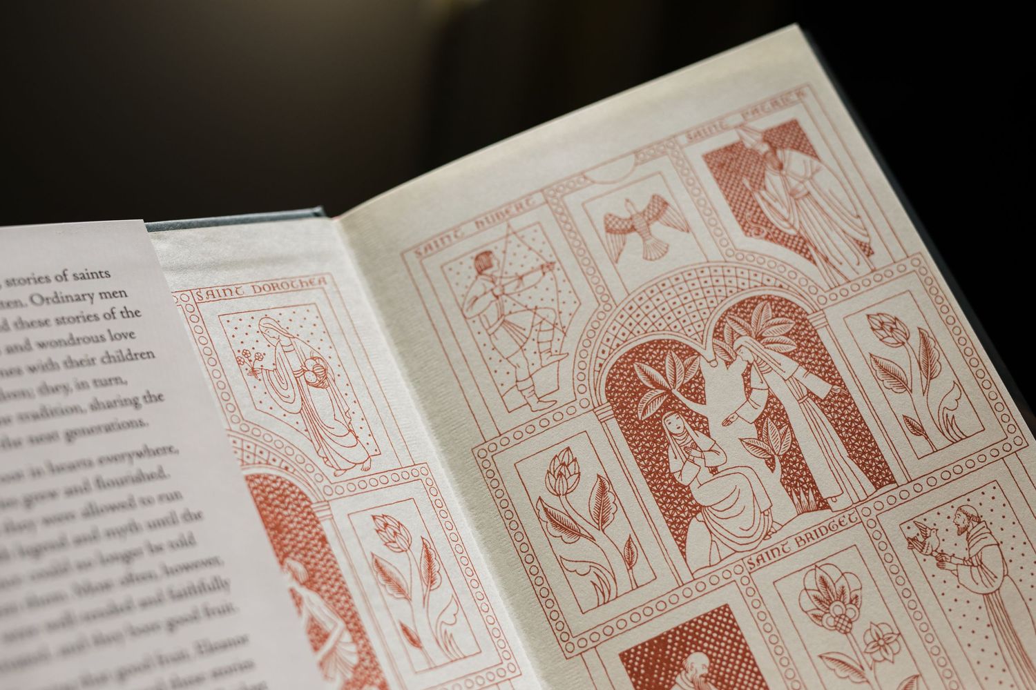 Open book displaying red illustrated pages with decorative patterns and text layouts.
