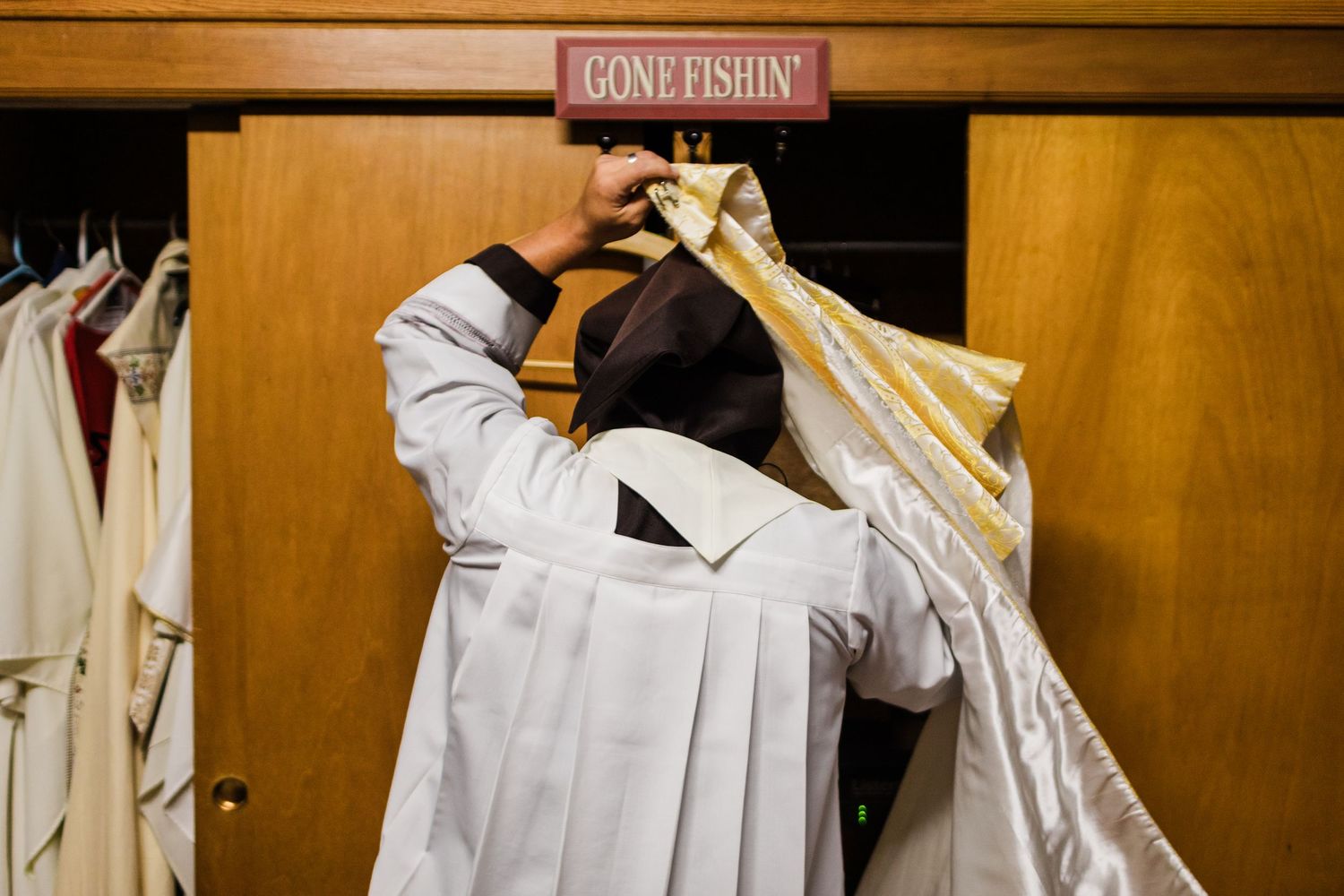 A wooden confessional booth sign mounted on a wall in a church.