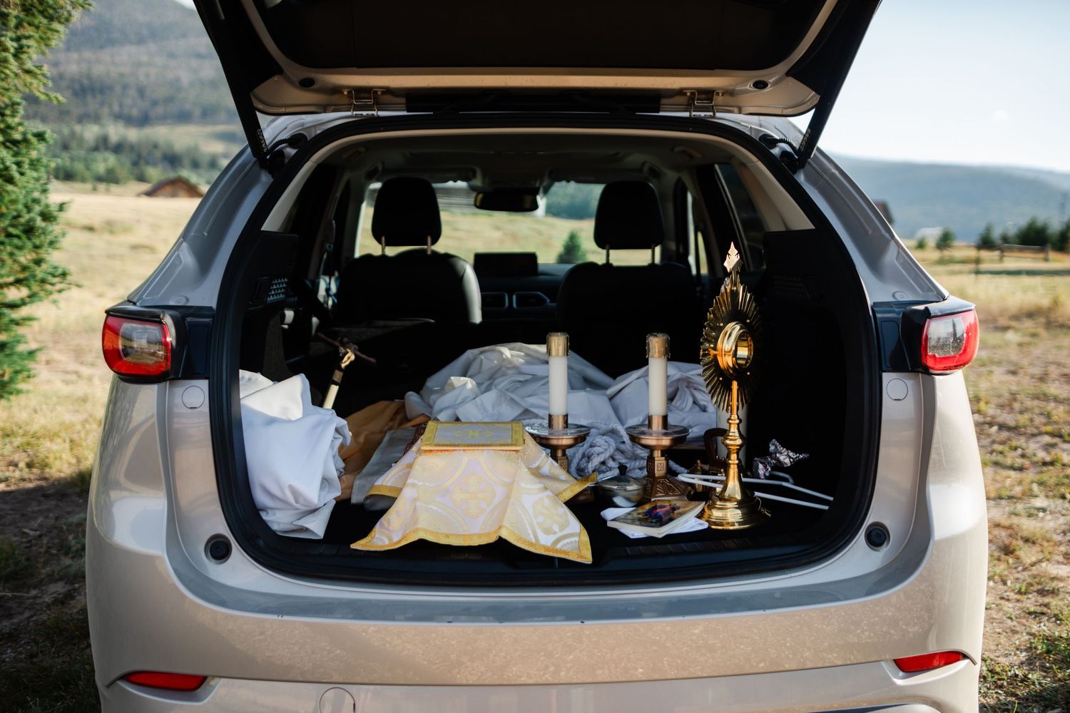 Camping gear and supplies neatly packed in the back of an SUV with an open trunk.