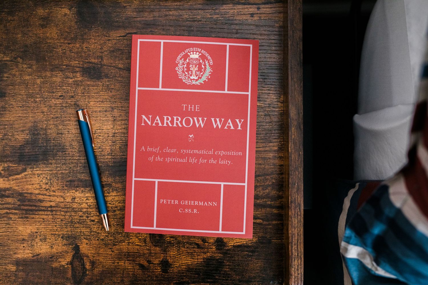 A rustic wooden wall with a red sign reading 'The Narrow Way' mounted against distressed brown planks.