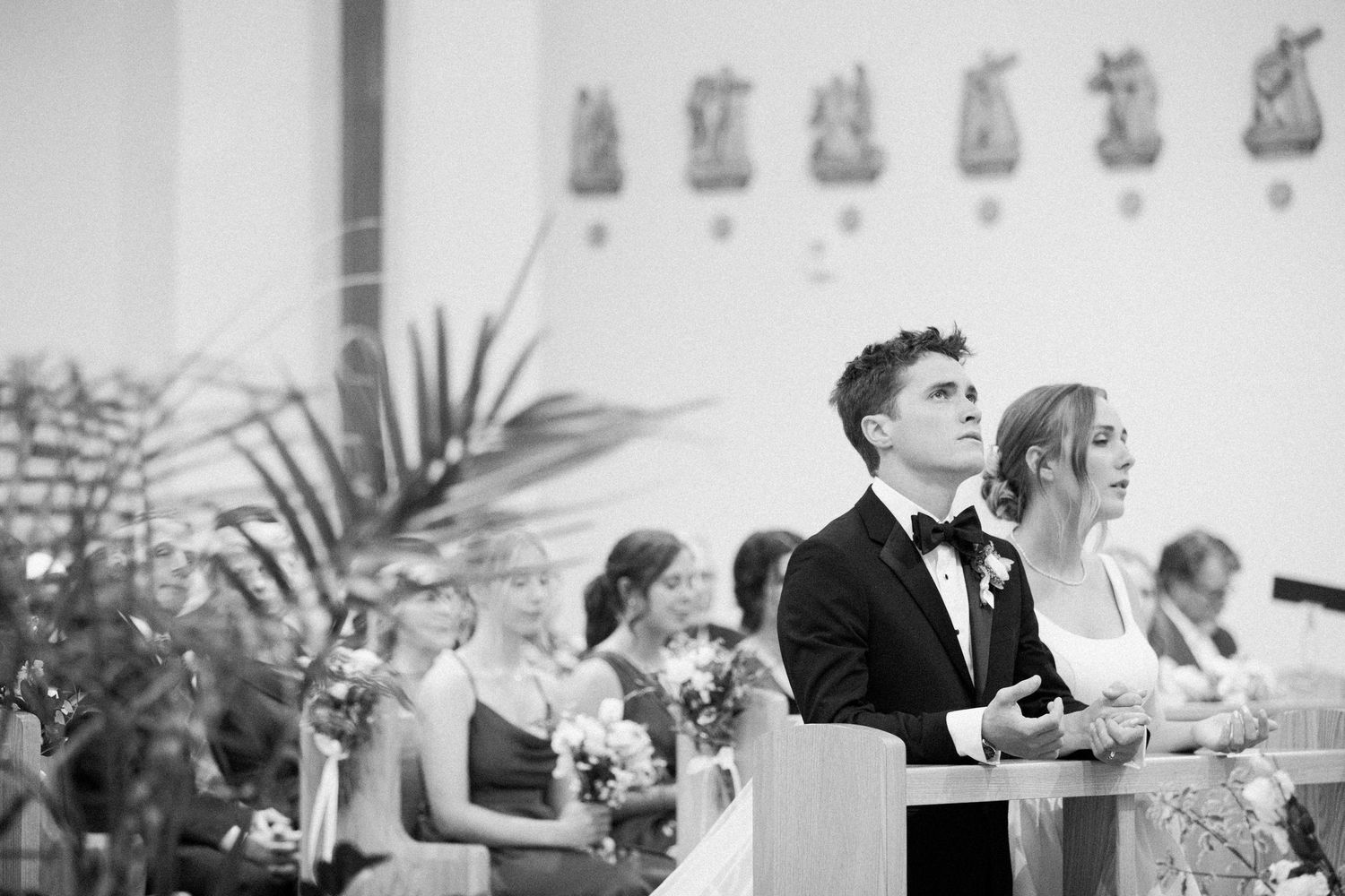 Black and white photo of wedding reception guests seated at tables during dinner and celebration.