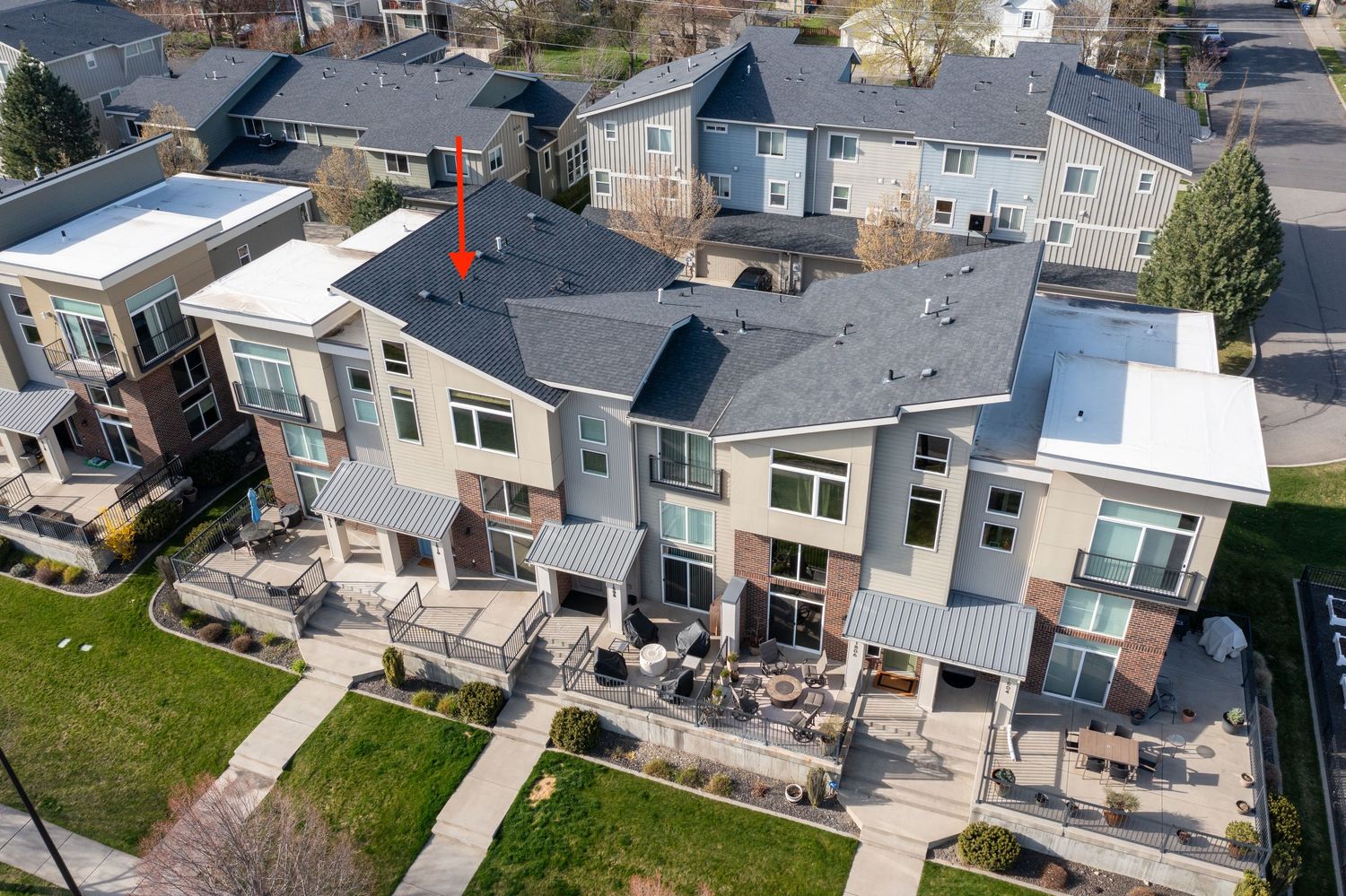 Aerial view of modern townhouses with patios and balconies in an urban residential neighborhood.